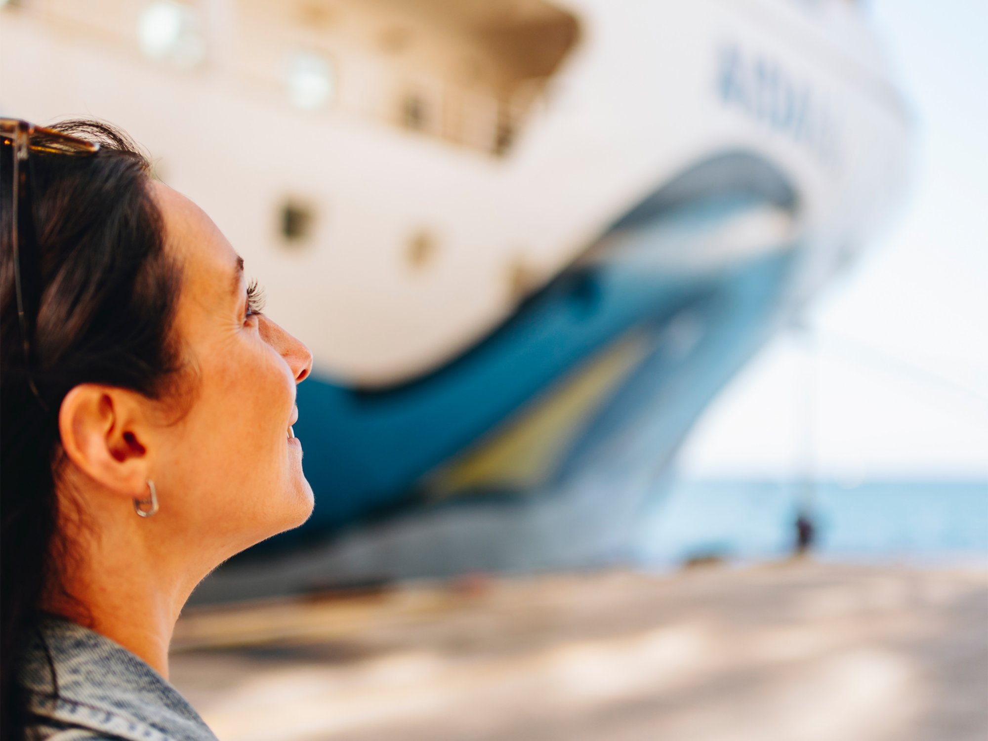 Frau vor dem AIDA Logo an Bord auf dem Sonnendeck