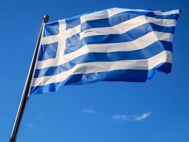 Greek flag waving in blue sky