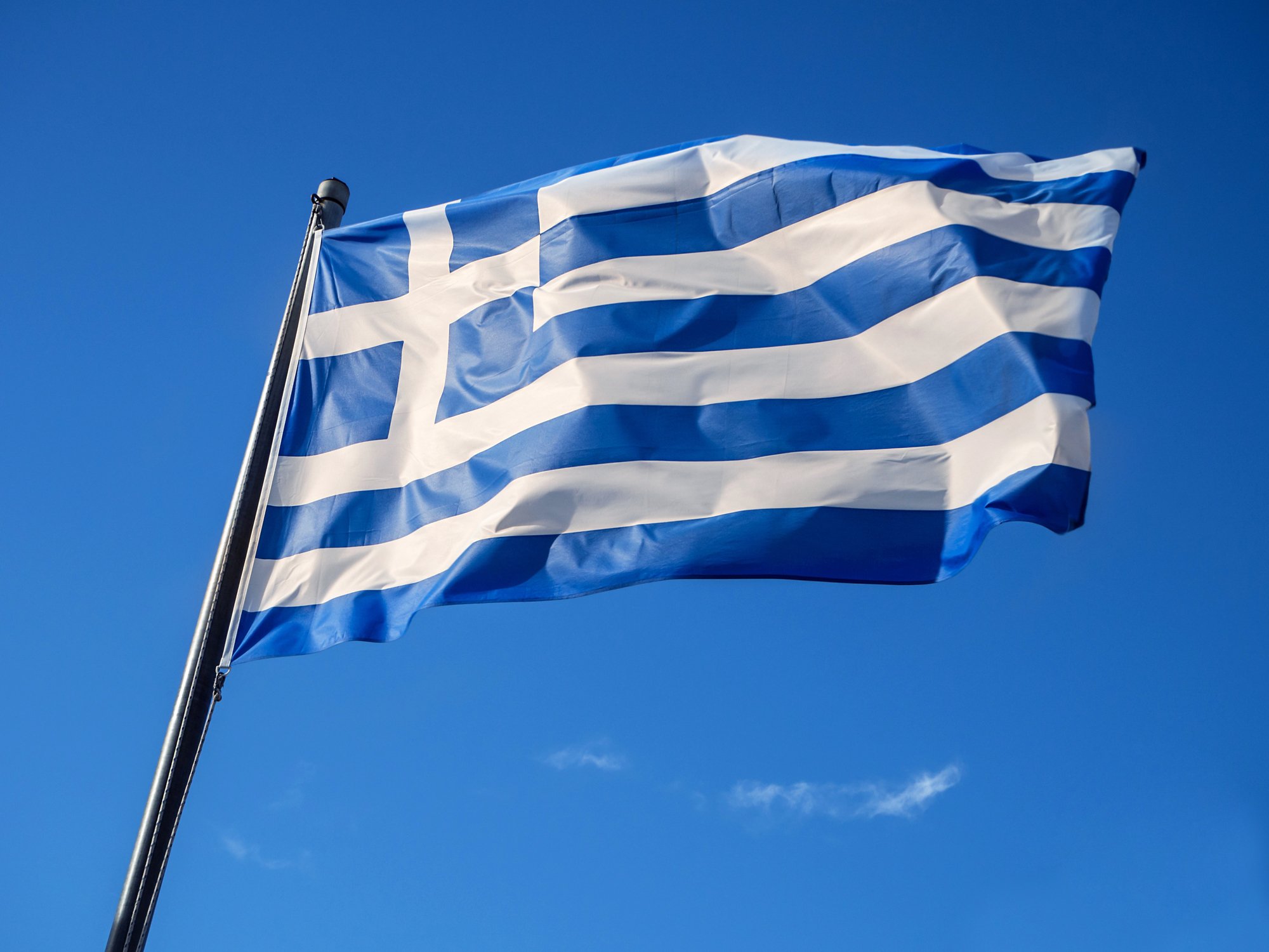 Greek flag waving in blue sky