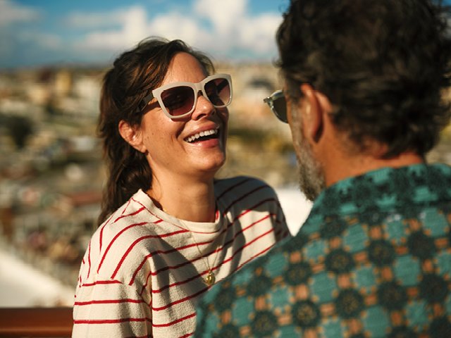 Eine Frau mit Sonnenbrille lacht
