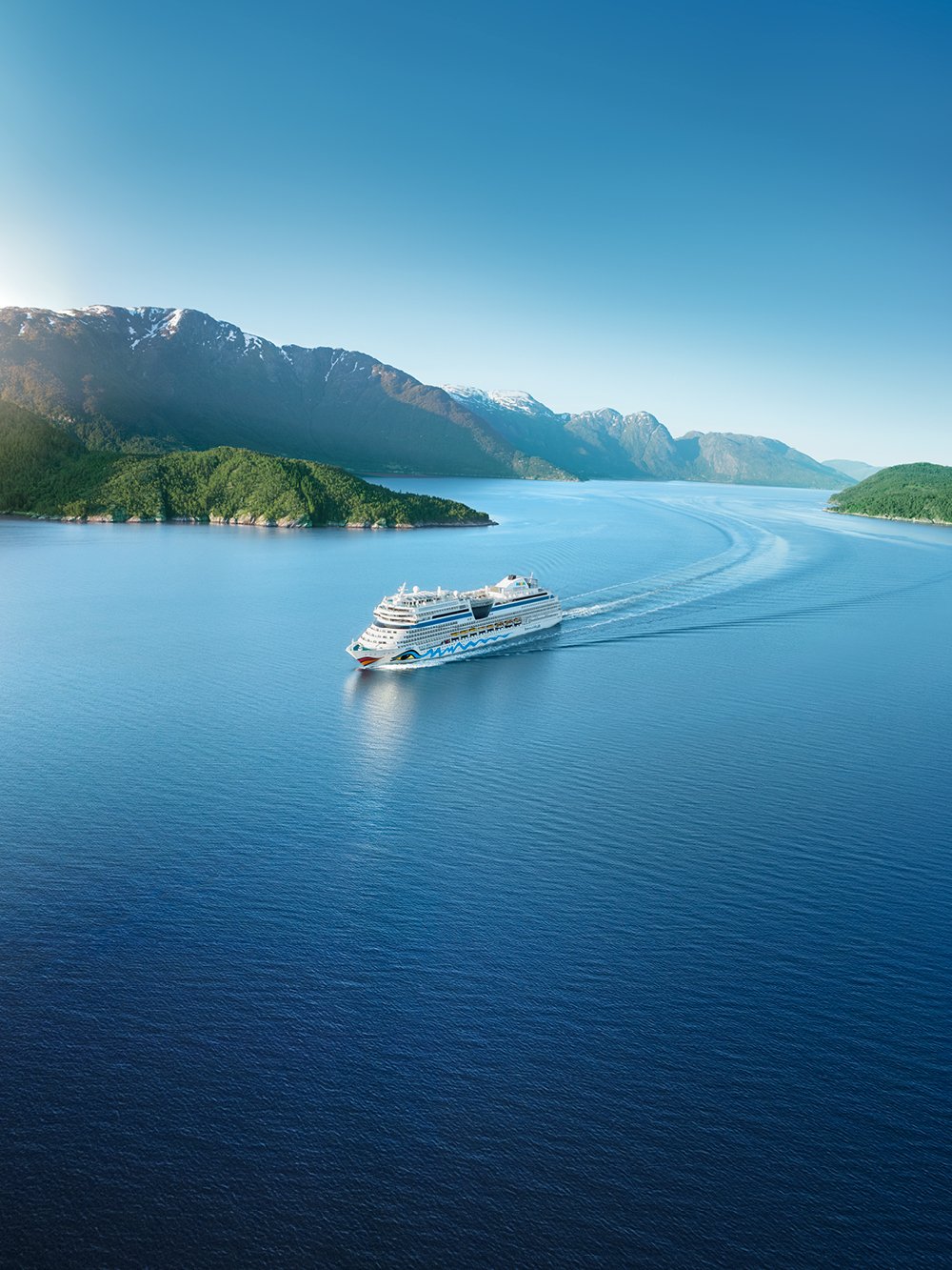 AIDA Schiff auf dem Wasser mit Bergen im Hintergrund