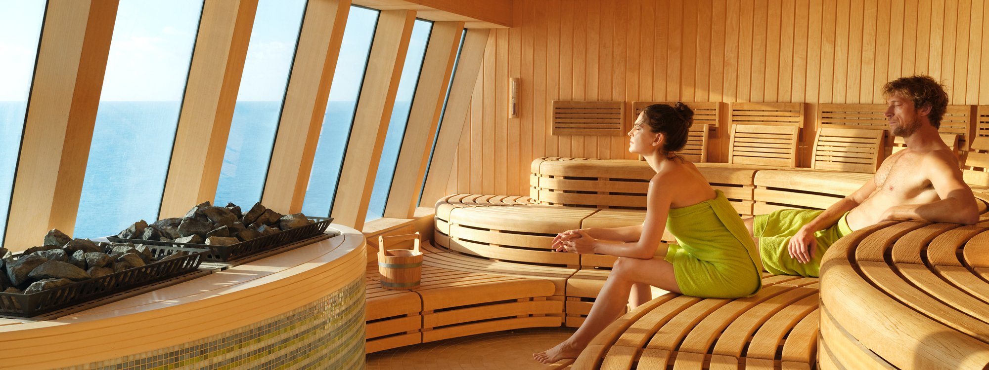 Ein Pärchen in einer geräumigen Sauna mit Meerblick