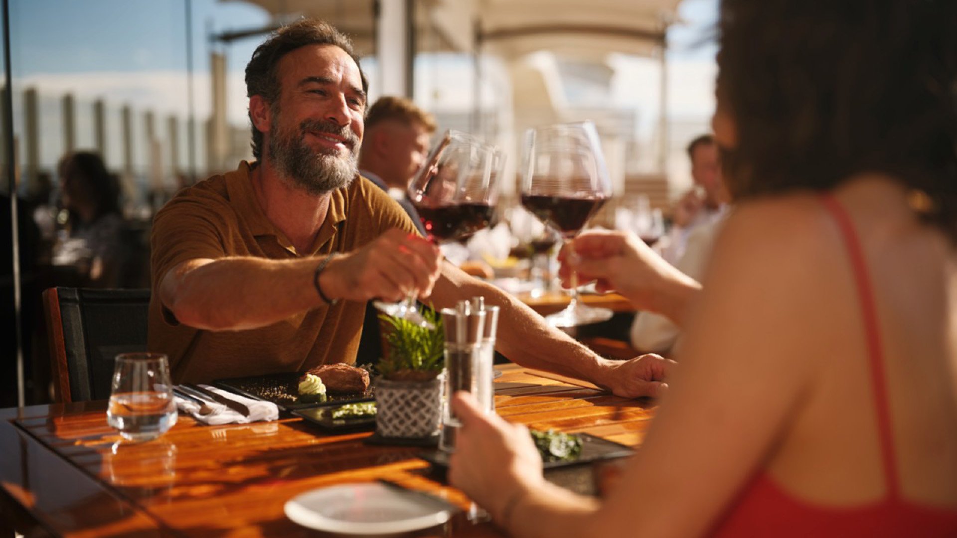Paar stößt mit einem Glas Wein auf 30 Jahre AIDA an