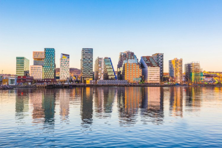 Modern buildings in Oslo, Norway, with their reflection into the water. These are some of the new buildings in the neighbourhood of Bjorvika. Concepts of travel and architecture.; Shutterstock ID 350327231; Kunde (Pflichtfeld): -; Projekt (Pflichtfeld): -