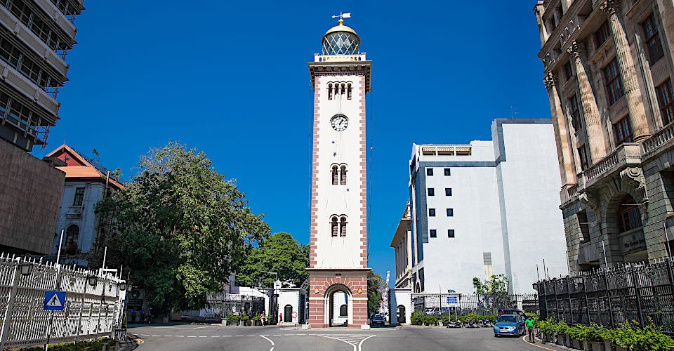 COLOMBO, SRI LANKA-DEC 24, 2016:The historic building of the lighthouse nowadays located among the highrises of the Fort district and functioning as the clock tower Colombo on Dec 24, 2016. Sri Lanka.