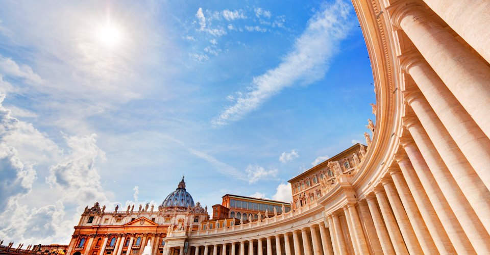 St. Peter&#39;s Basilica colonnades, columns in Vatican City. Blue sunny sky