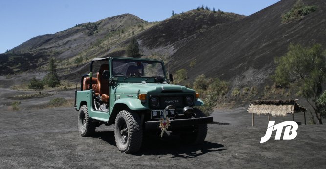 TOUR OPERATOR GATEWAY - Classic Green Jeep Parked Amidst the Black Sand Slopes of Mount Batur