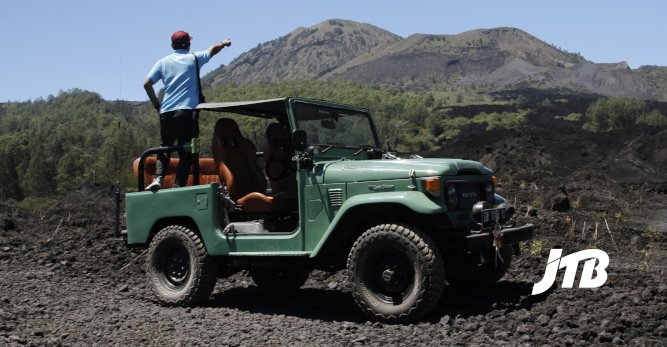 TOUR OPERATOR GATEWAY - Adventurer Pointing Towards the Summit of Mount Batur During a Jeep Tour