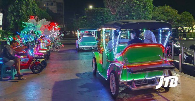 TOUR OPERATOR GATEWAY - Visitors enjoy illuminated car rides, creating a lively and colorful night scene