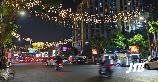 TOUR OPERATOR GATEWAY - Streets sparkle with decorative lights and lively traffic under the night sky