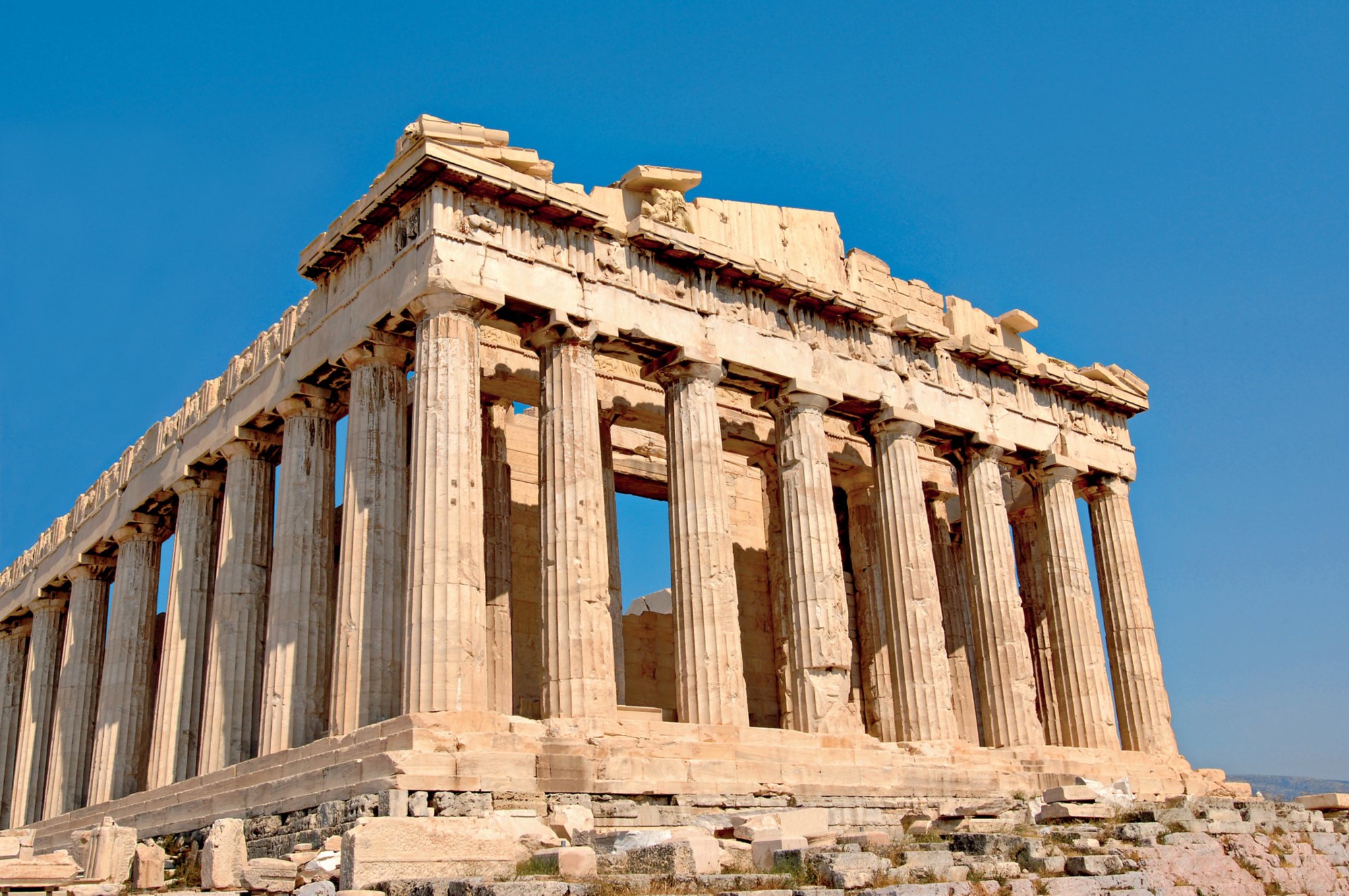 Der Parthenon-Tempel auf der Akropolis in Athen bei klarem Himmel, mit dorischen Säulen und sichtbaren historischen Schäden.