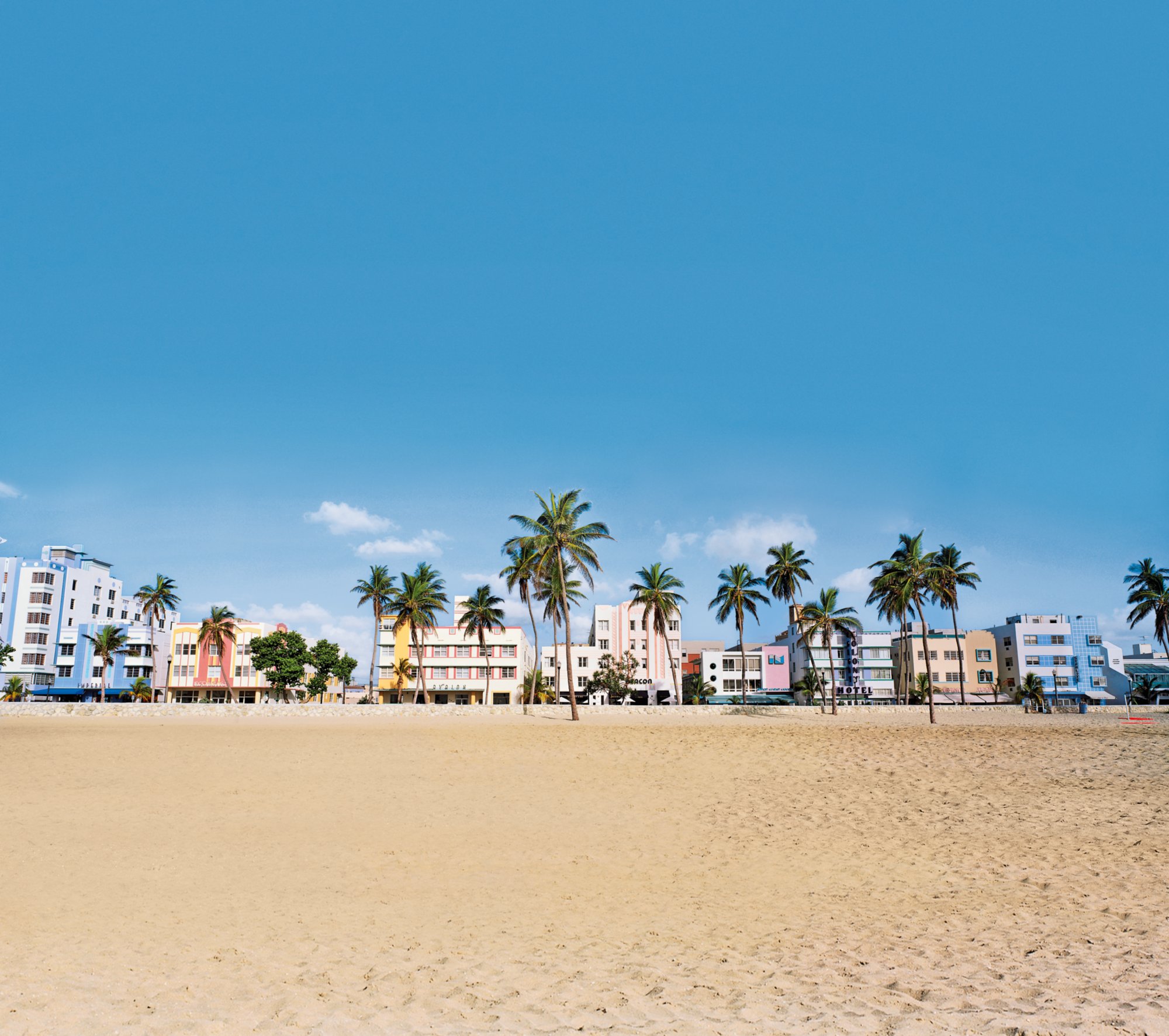 This is the art deco district of South Beach Miami. The buildings are painted in pastel colors surrounded by tropical palm trees.