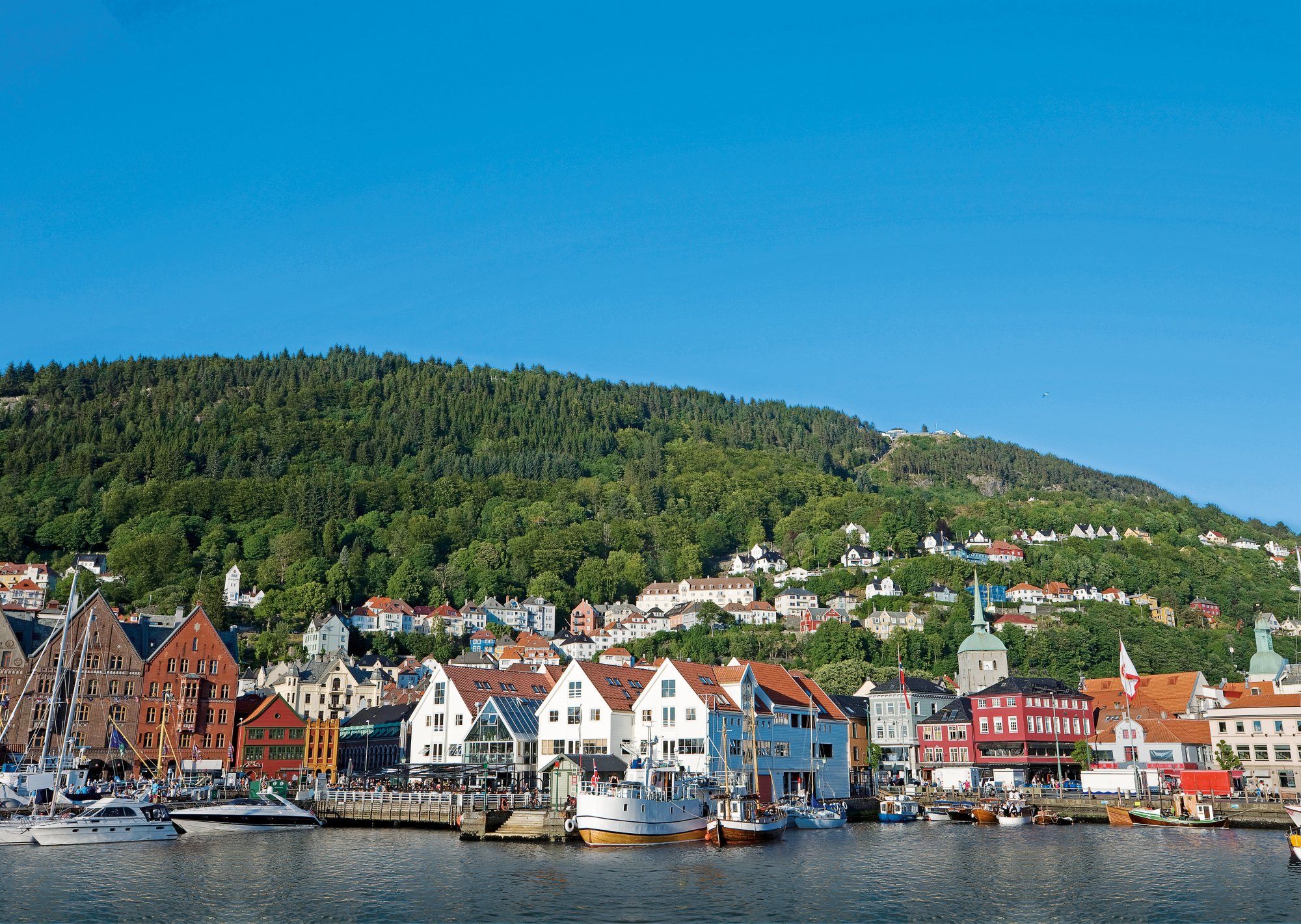 Blick vom Wasser auf Häuser in Bergen