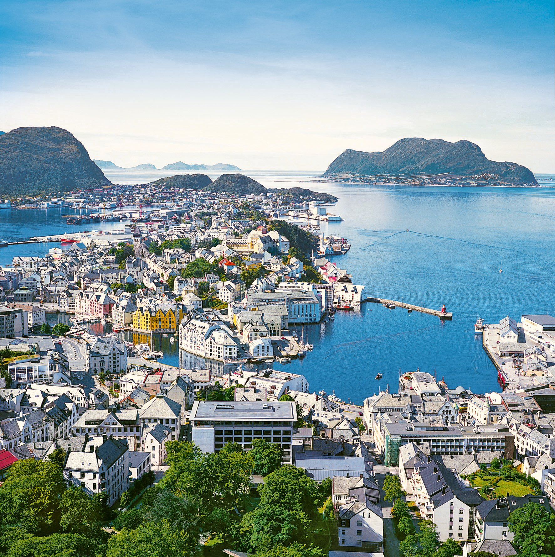 Blick auf Ålesund mit Fjord im Hintergrund und türkisblauem Wasser