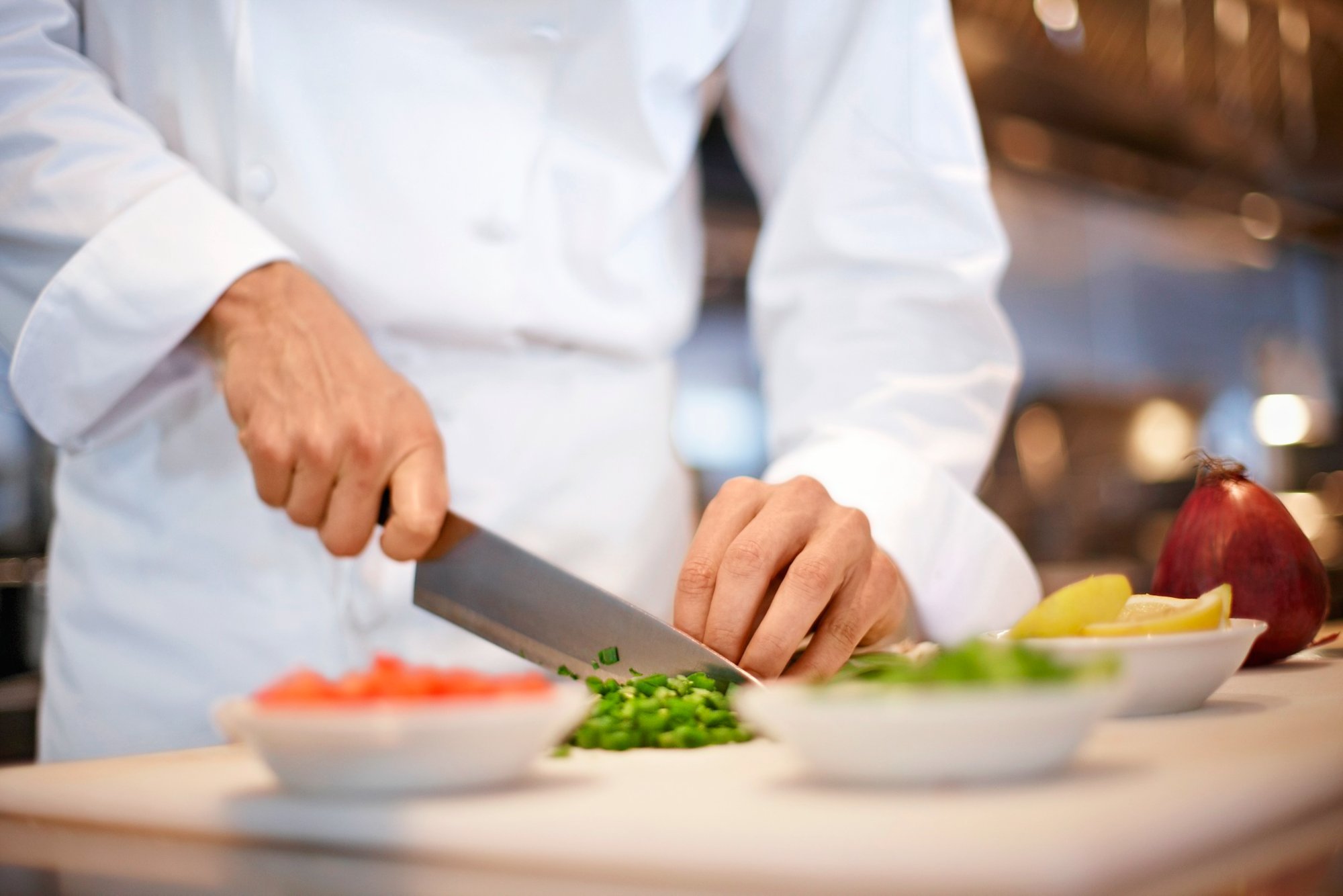 Koch schneidet mit einem Messer Zutaten klein