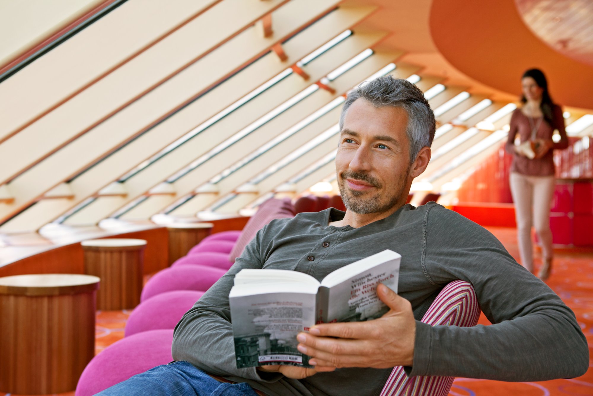 Man sitzt in einer Lounge und liest ein Buch