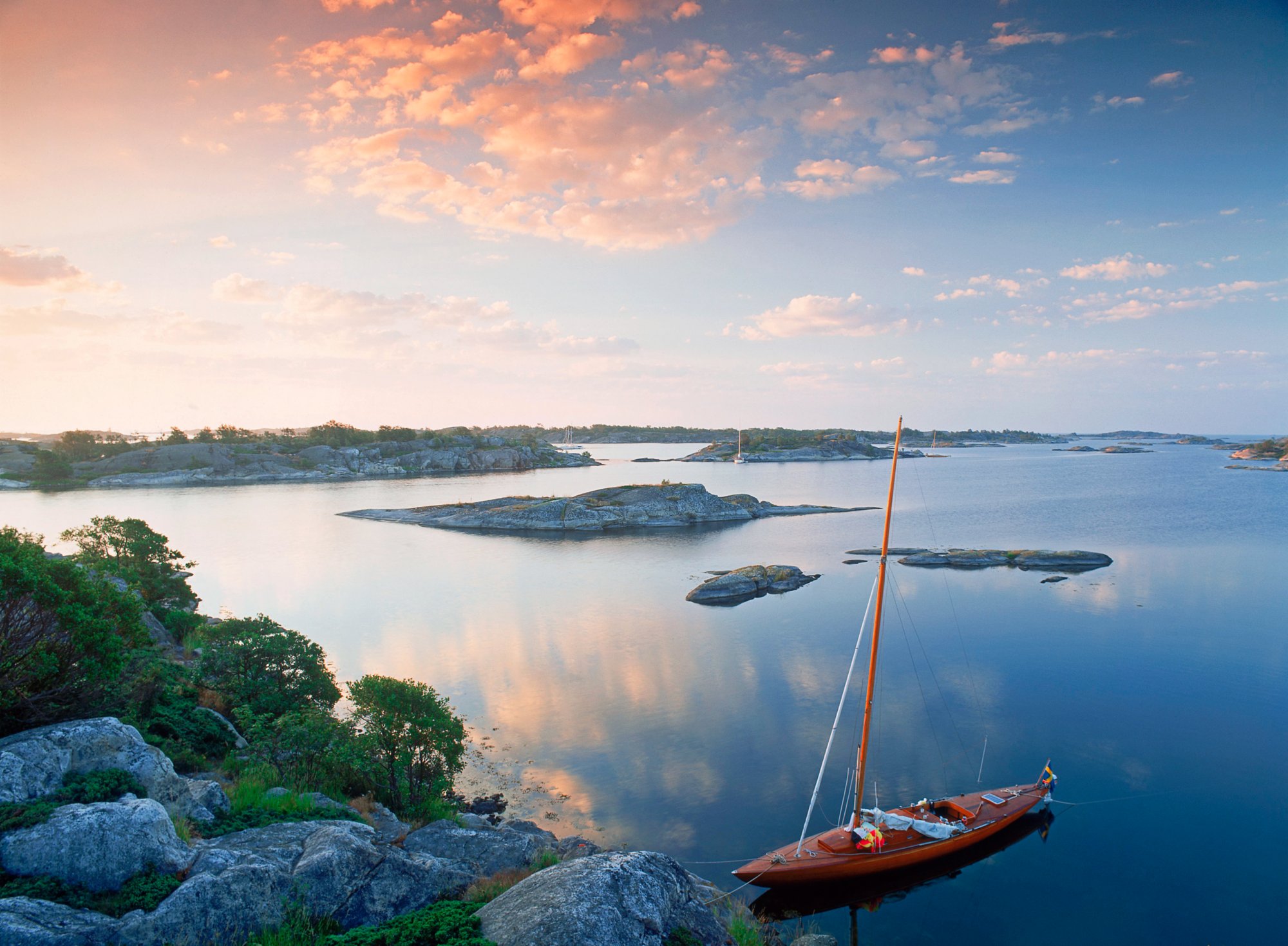 Sailboat moored on rocks in Stockholm Archipelago at Stora Nassa island group at sunrise