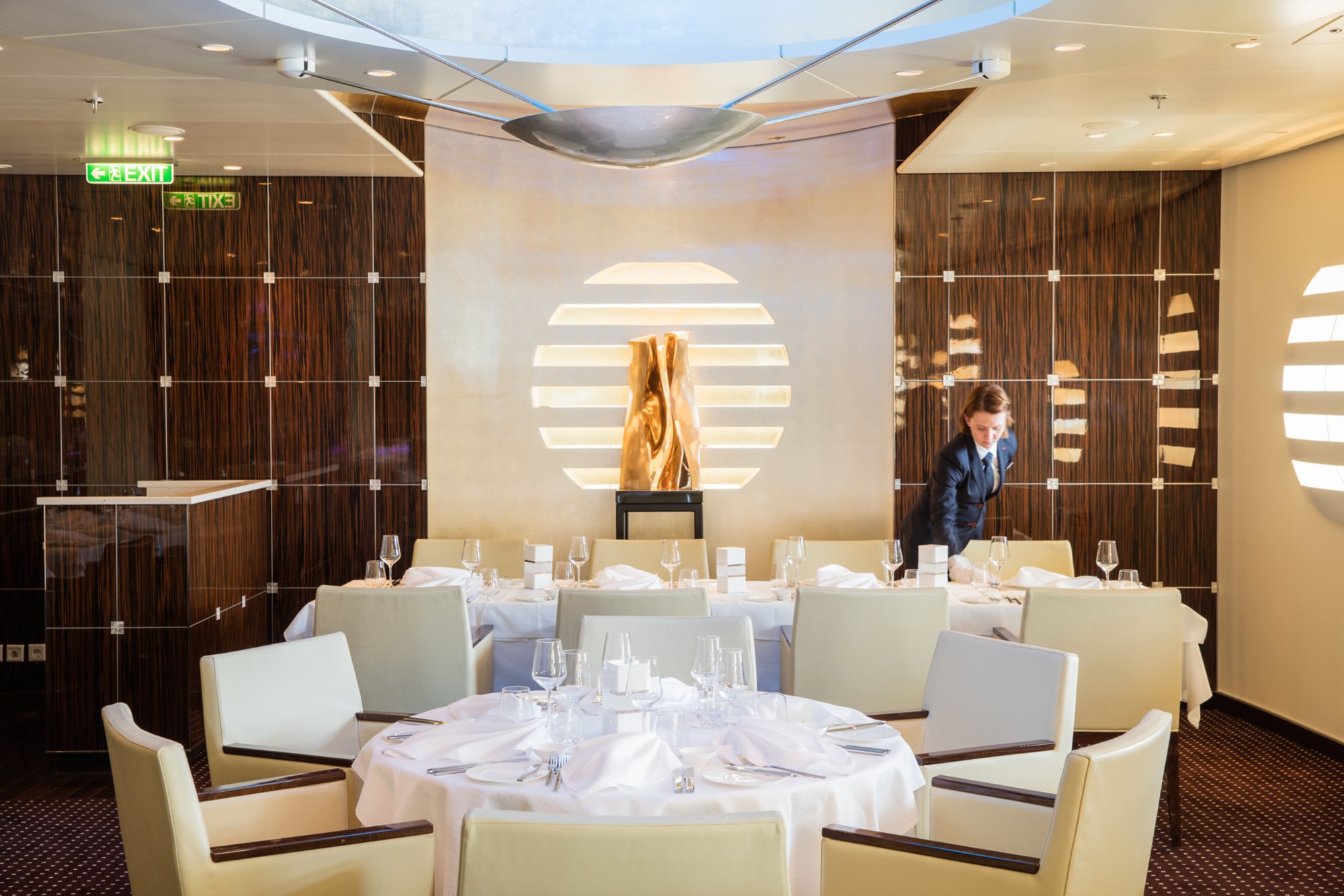Ein runder Tisch im Restaurant mit Servietten und Geschirr schön gedeckt