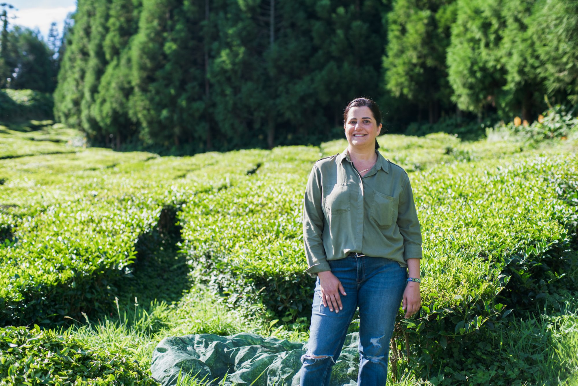 Eine Frau in Jeans stehtin der Natur