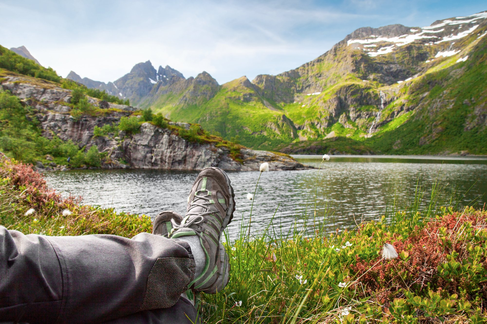 Hiker relaxing near mountain lake, Lofoten, Norway