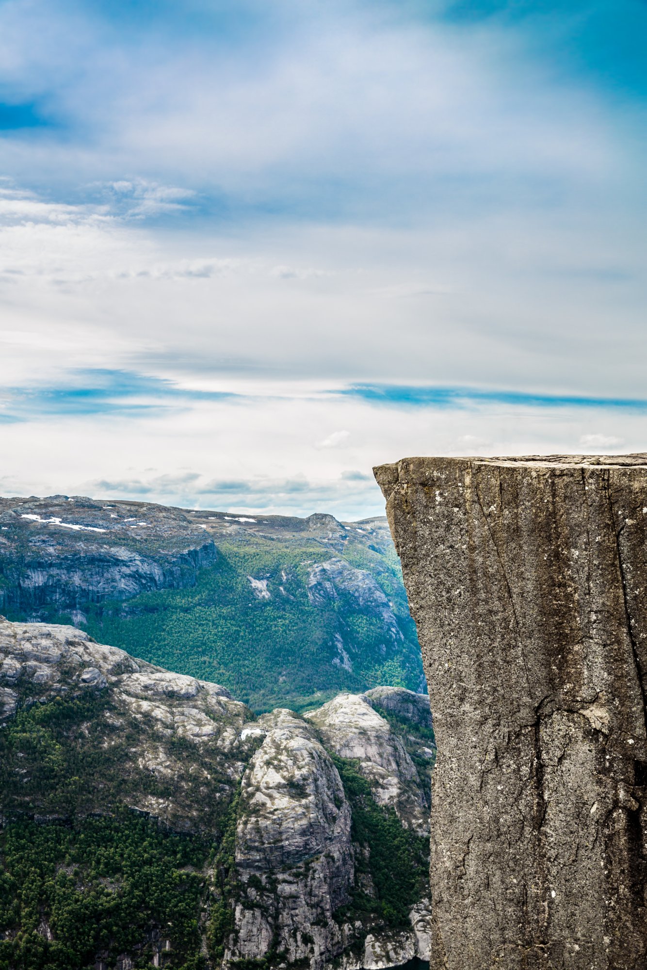 Preikestolen, die markante Felskanzel bei Stavanger, Norwegen, ragt über eine dramatische Berglandschaft unter teils bewölktem Himmel.