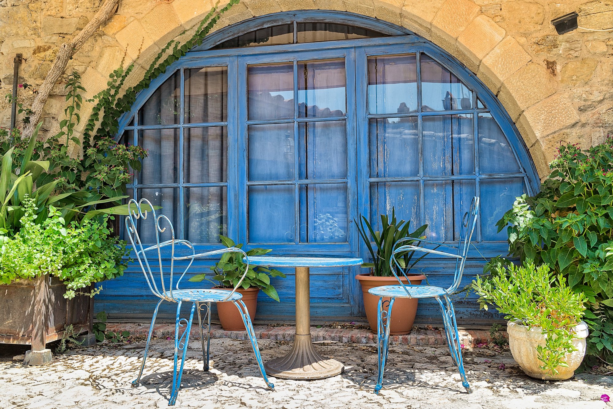 Zwei blaue Stühle und Tisch vor blauem Halbrundfenster