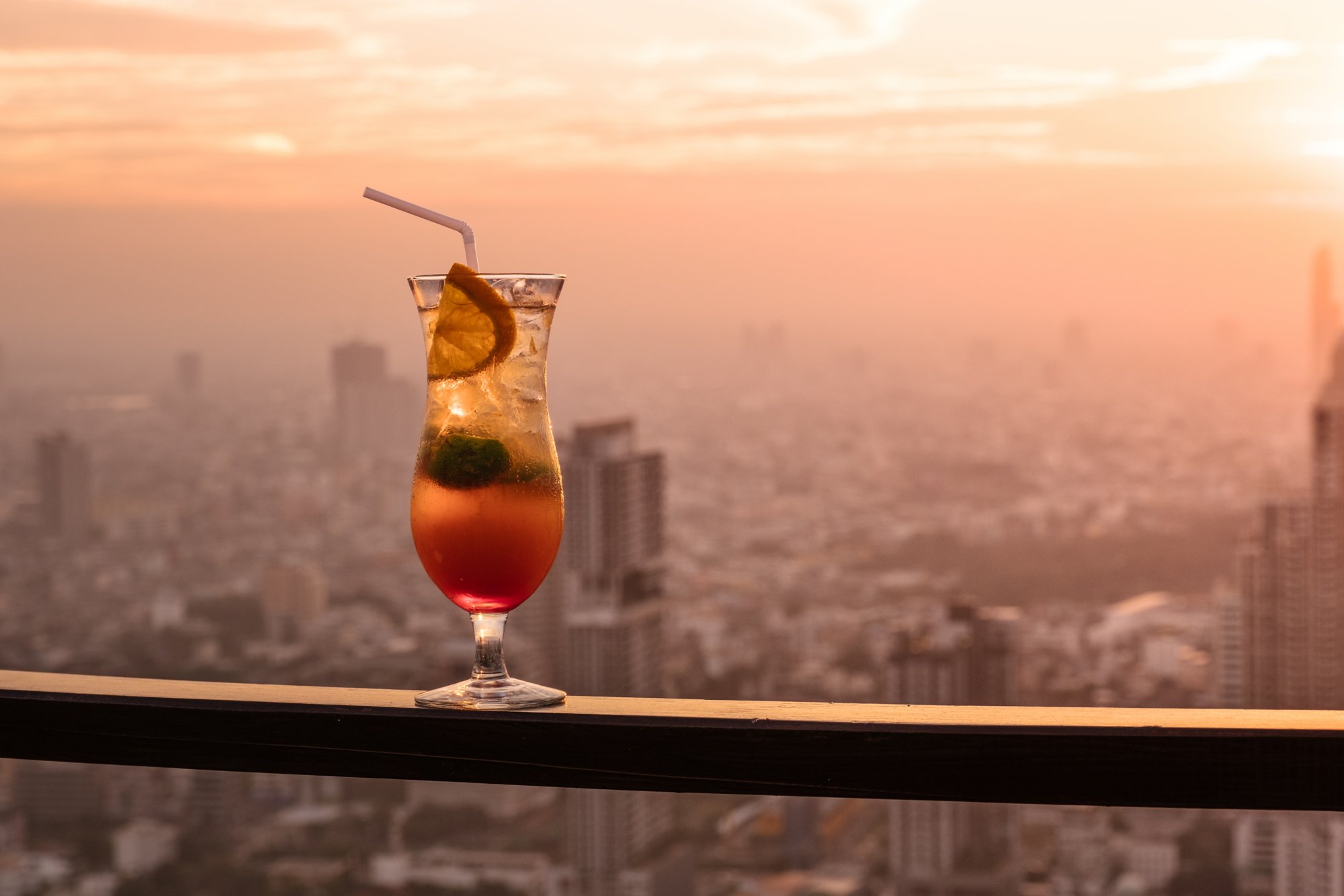 Glass of Cocktail Punch on Balcony with Sunset City View in the Background; Shutterstock ID 535654189; Purchase Order: -