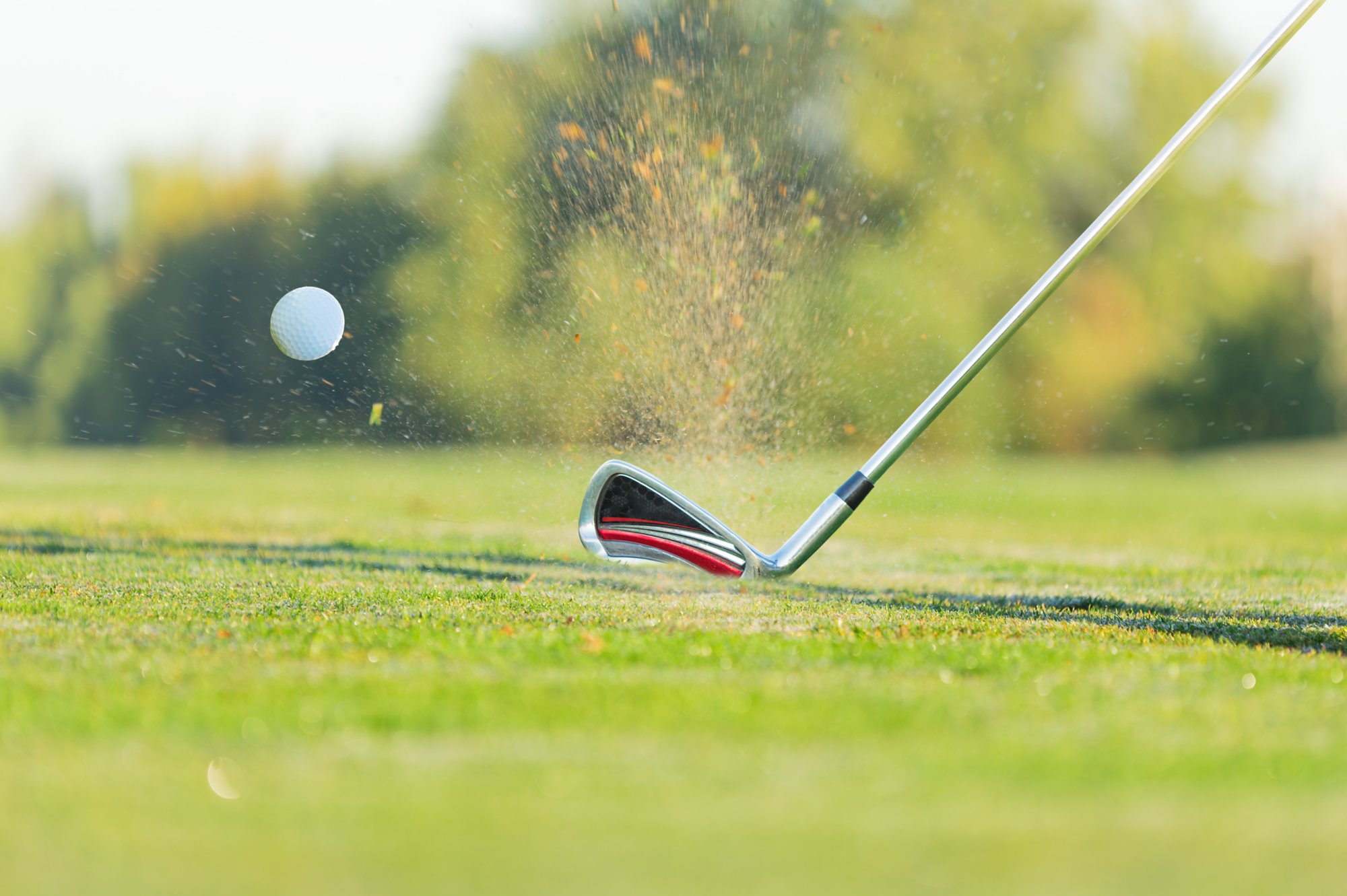 Close-up of golf ball with club during sunset