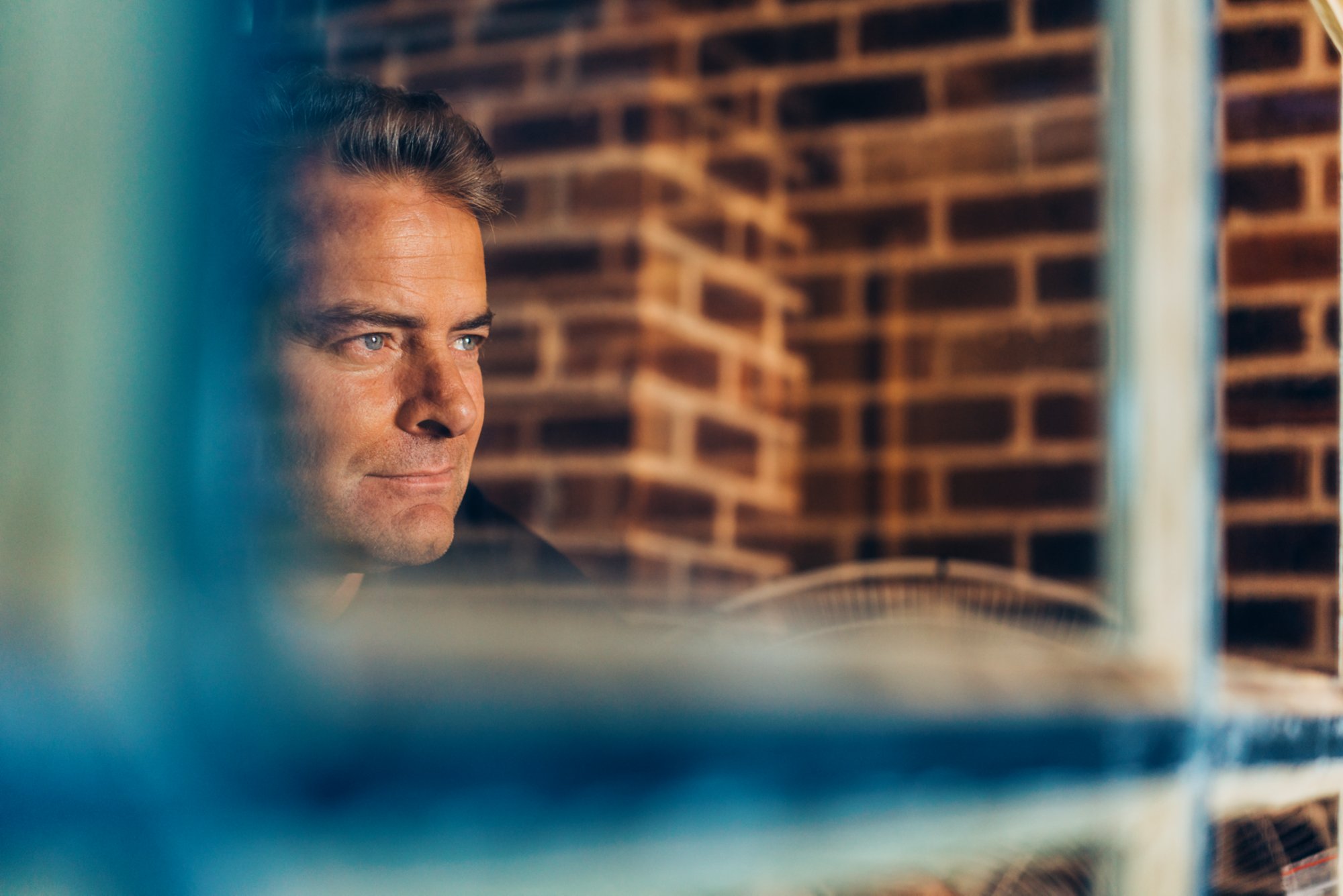 Mann schaut aus dem Fenster