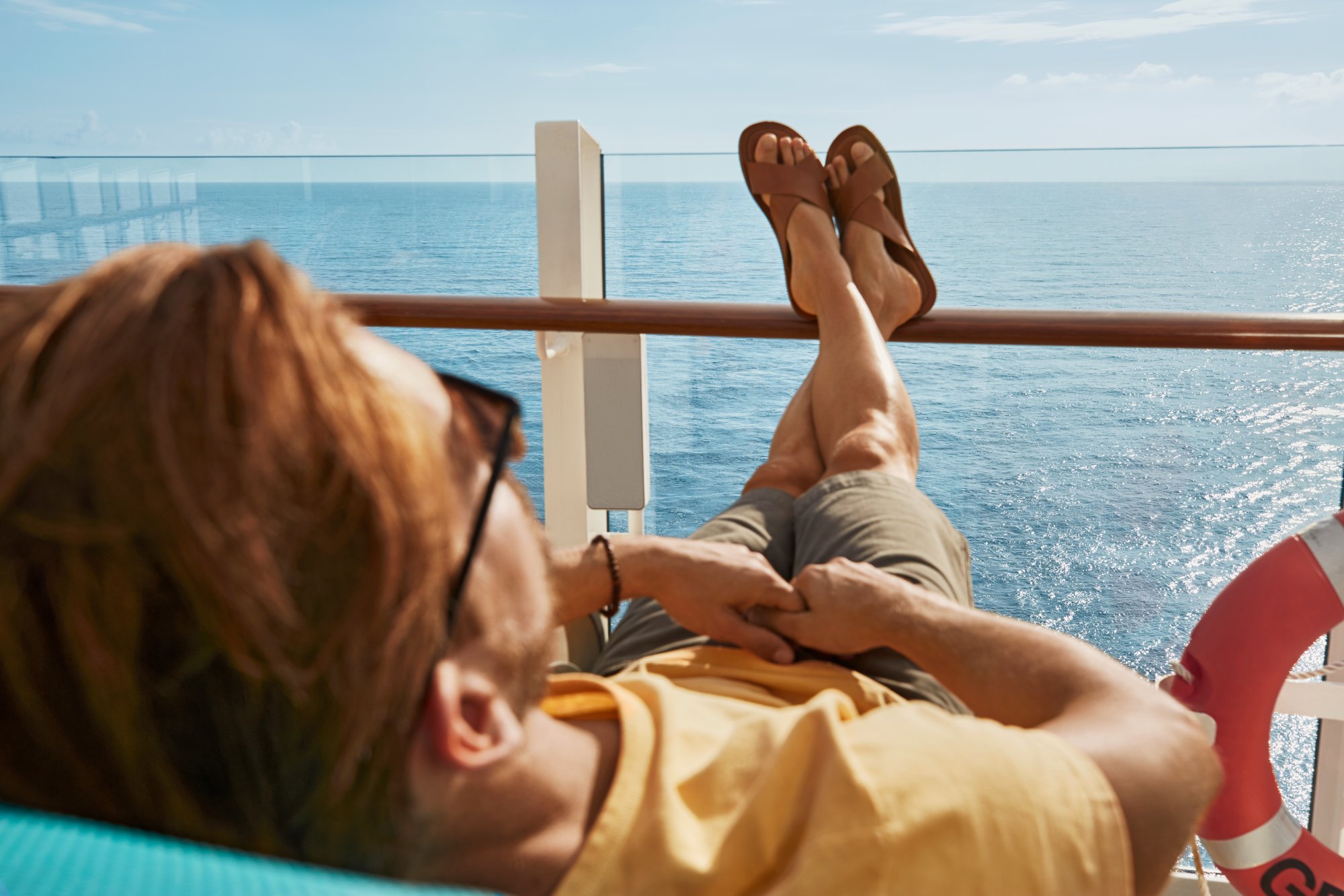 Frau hat die Füße auf die Reeling gelegt