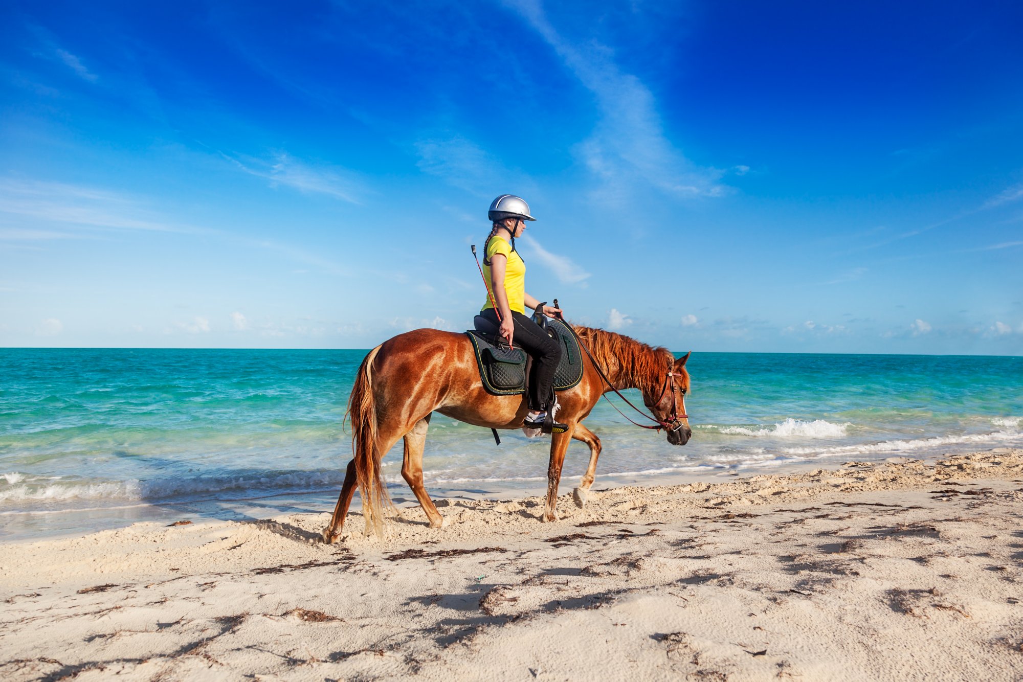 Teenage girl finishing a ride on Long Bay Beach, Providenciales, Turks and Caicos