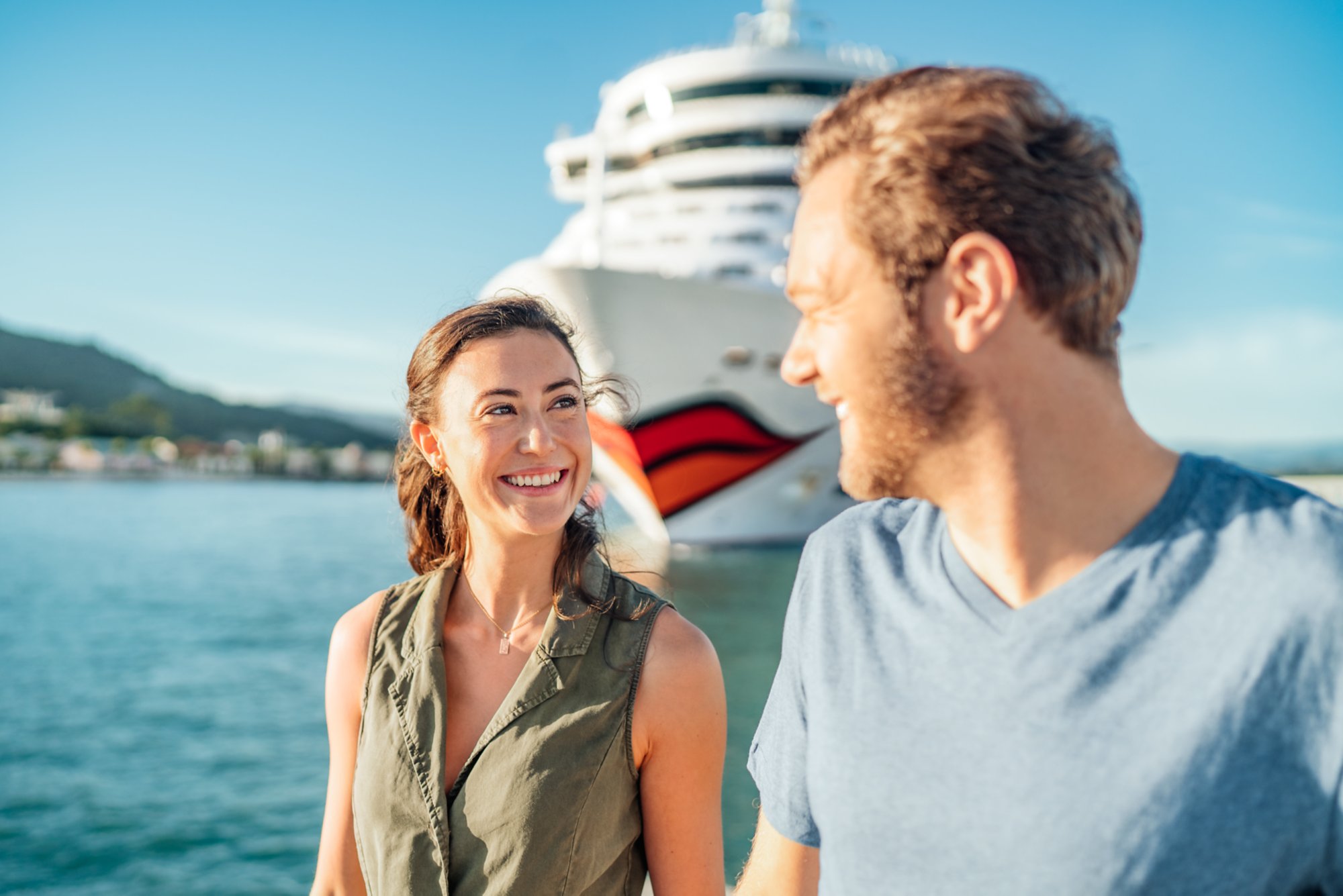 Pärchen steht im Hafen mit AIDA Schiff - Verlockung der Woche