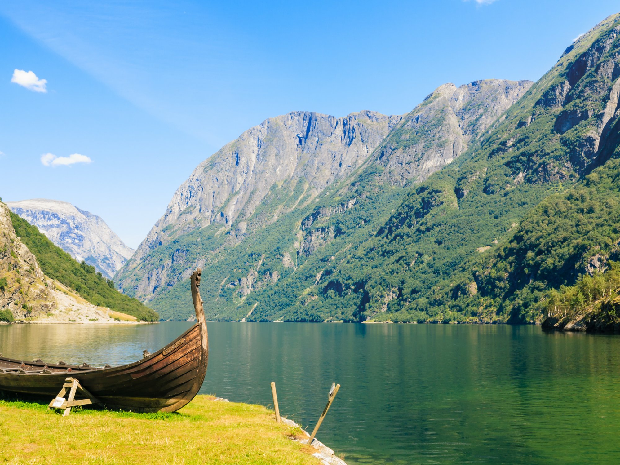 Tourism and travel. Mountains and fjord Sognefjord in Norway, Scandinavia. Old viking boat on seashore.