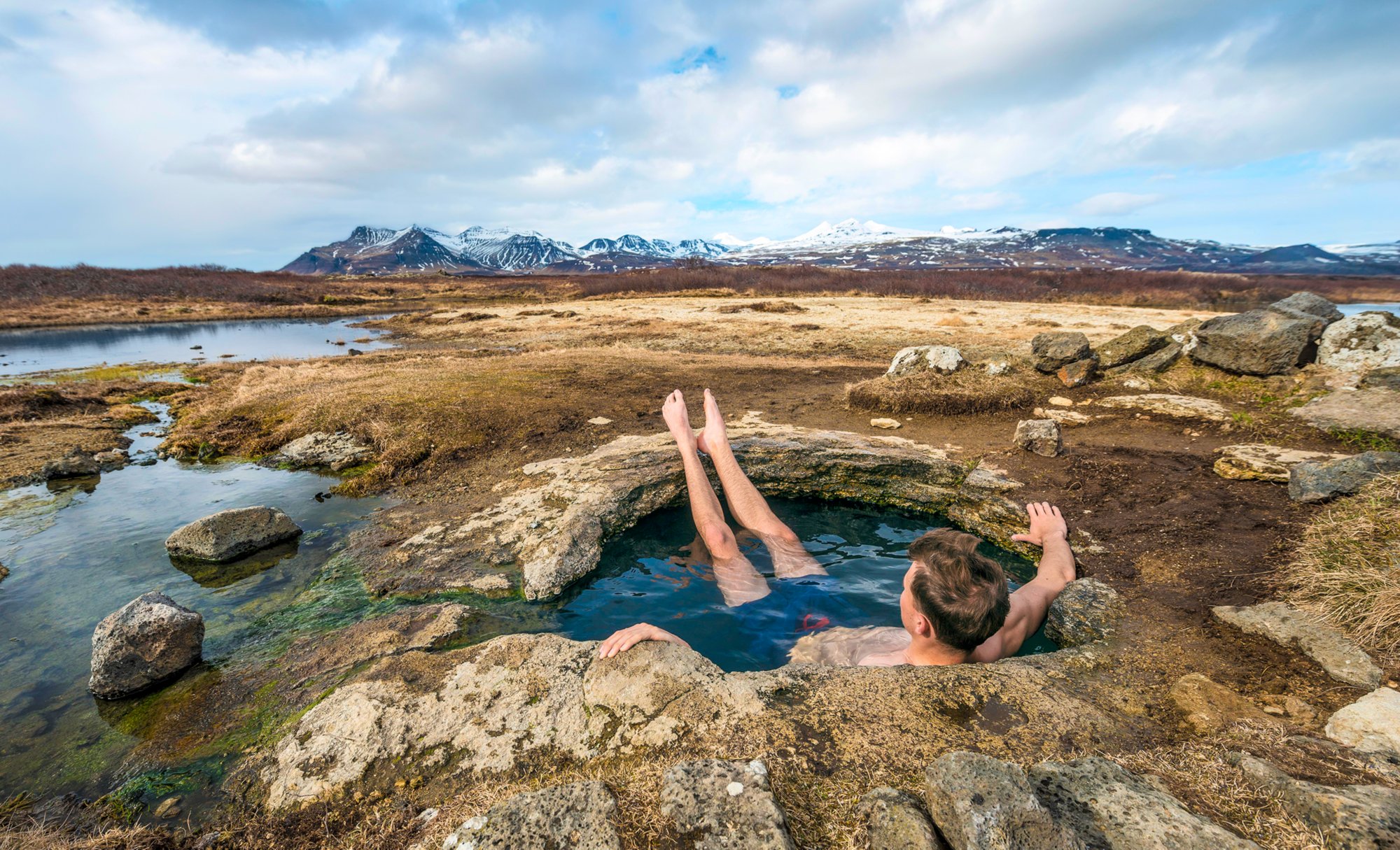 Young man in a hot spring, near Eyjar og Miklaholt, Vesturland, Iceland, Europe