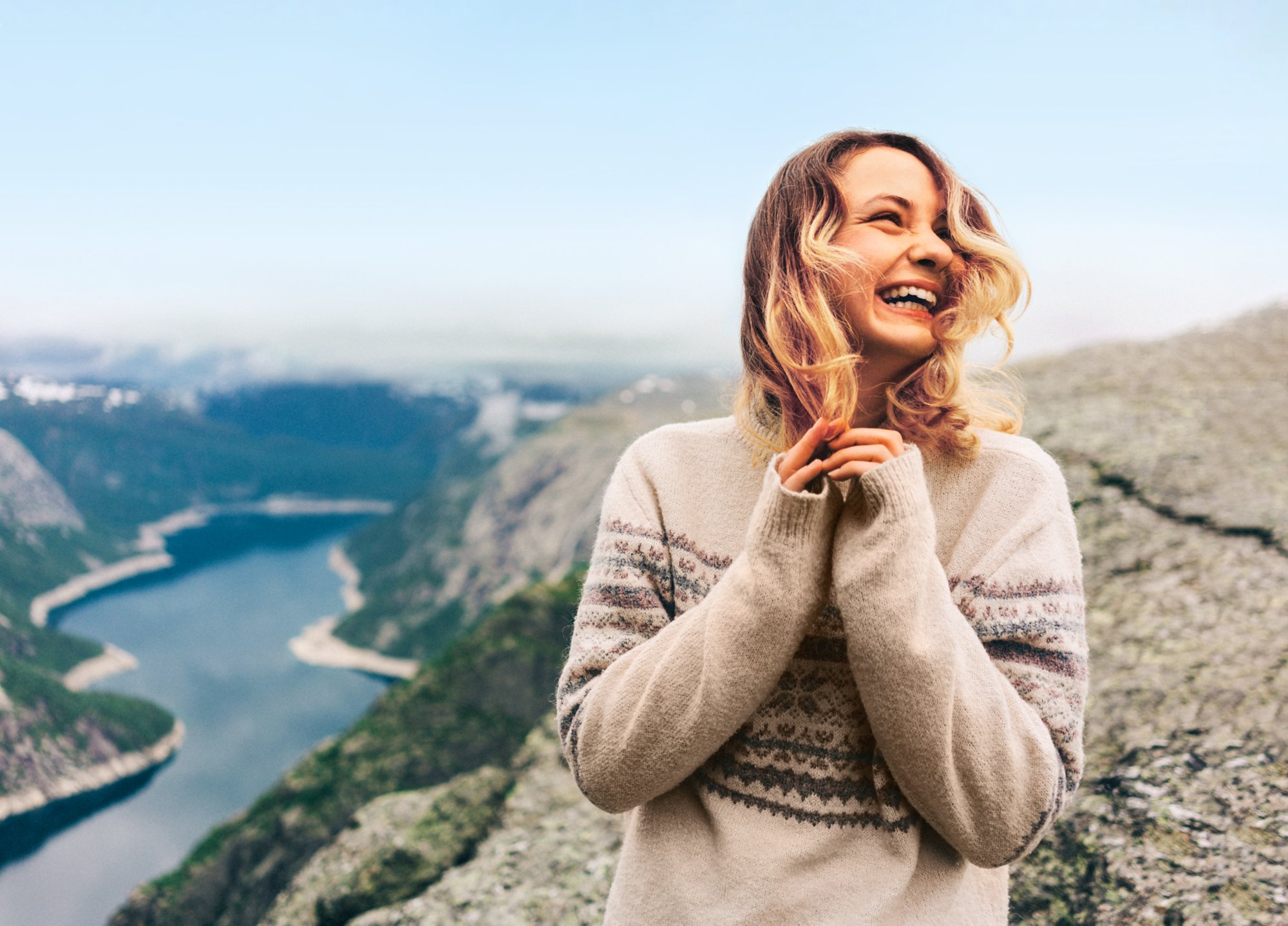 Eine Frau in Wollpullover auf einem Berg