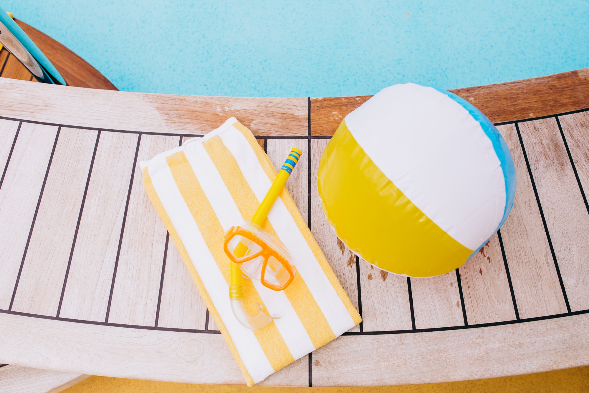 Wasserball und Handtuch am Pool