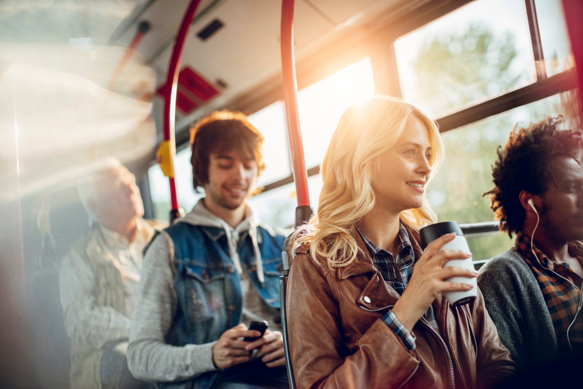 Menschen im Bus mit Musik in den Ohren und Getränken in der Hand