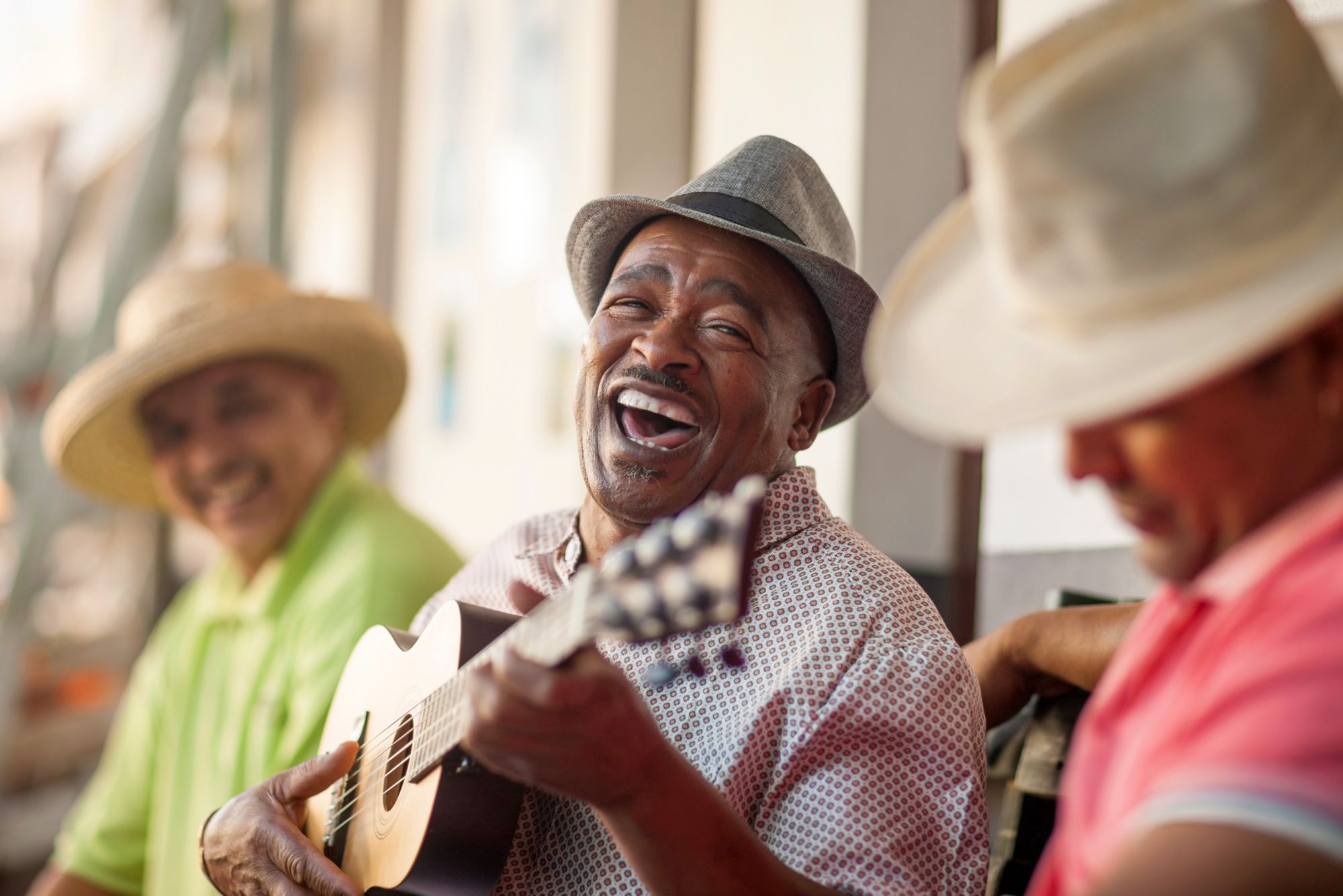 Mann spielt Ukulele und lacht