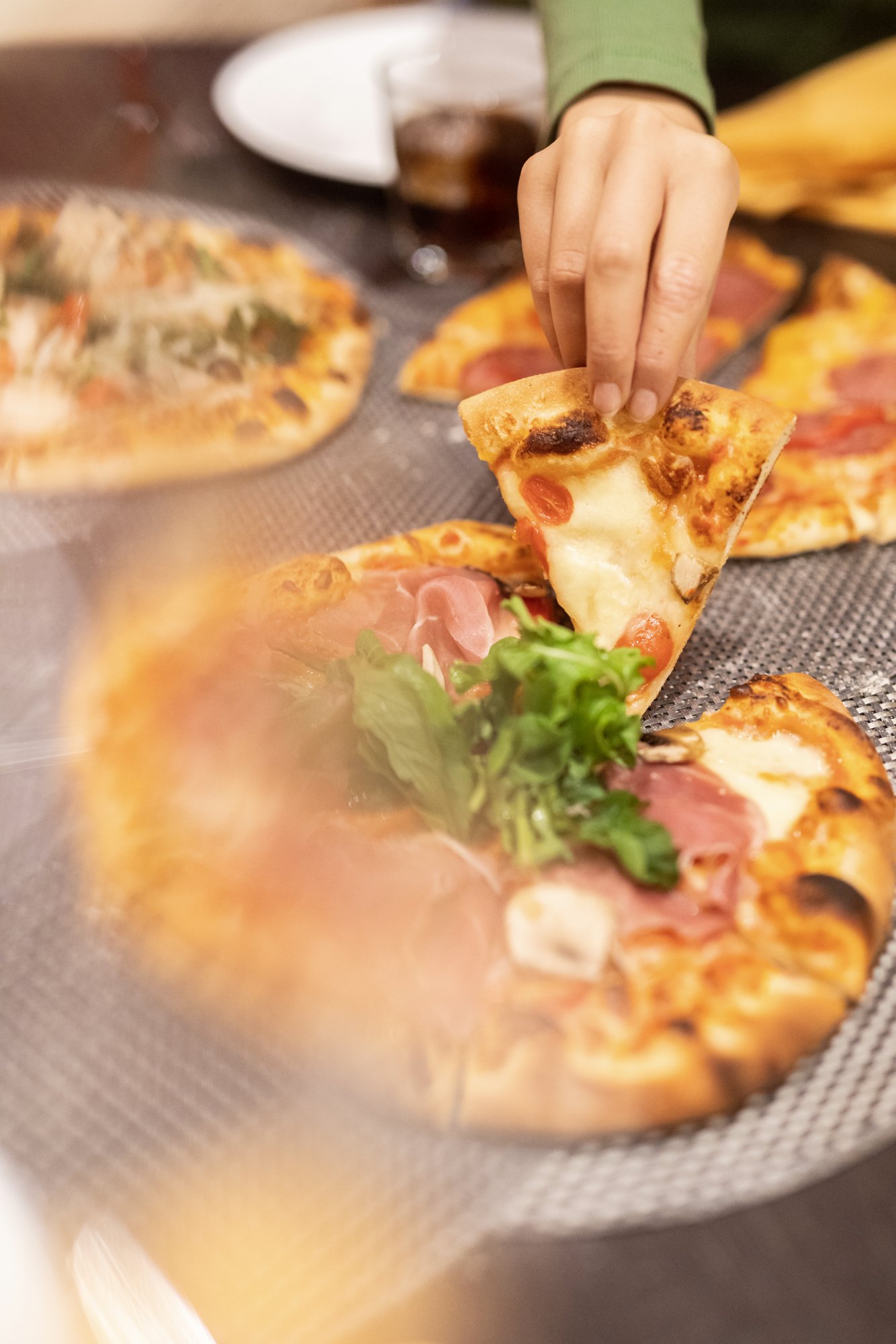 Menschen greifen Pizzastücke