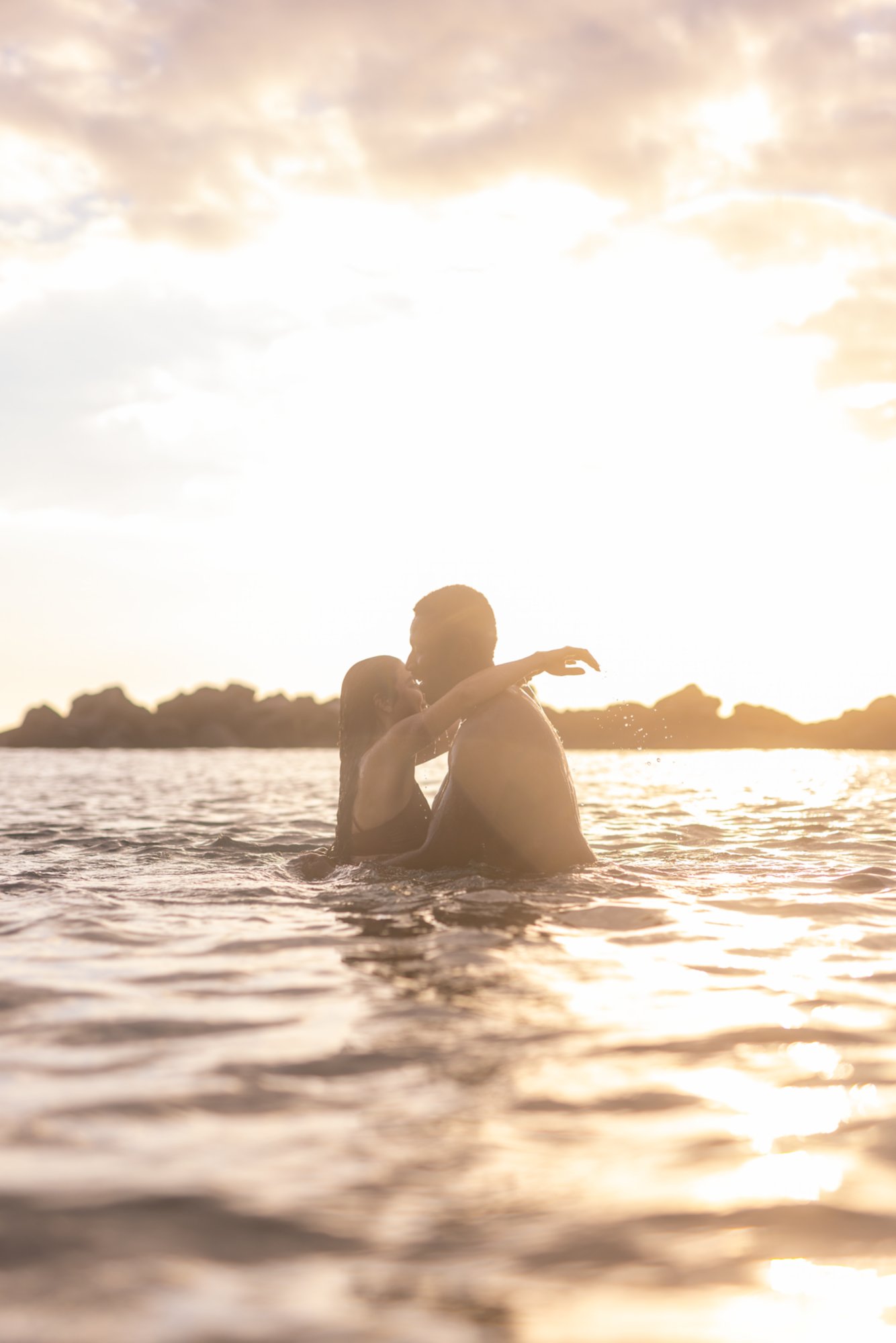 Paar umarmt sich bei Sonnenuntergang im Wasser