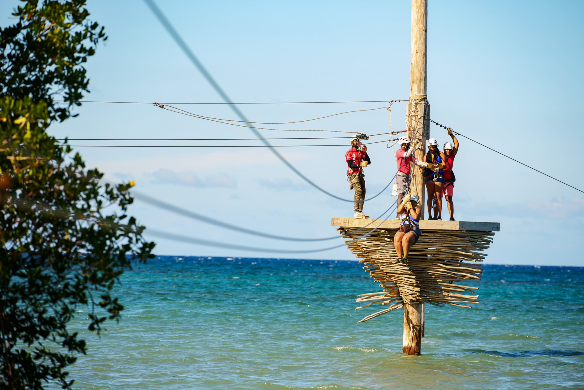 Vier Menschen auf einer Seilbahn über dem Meer          