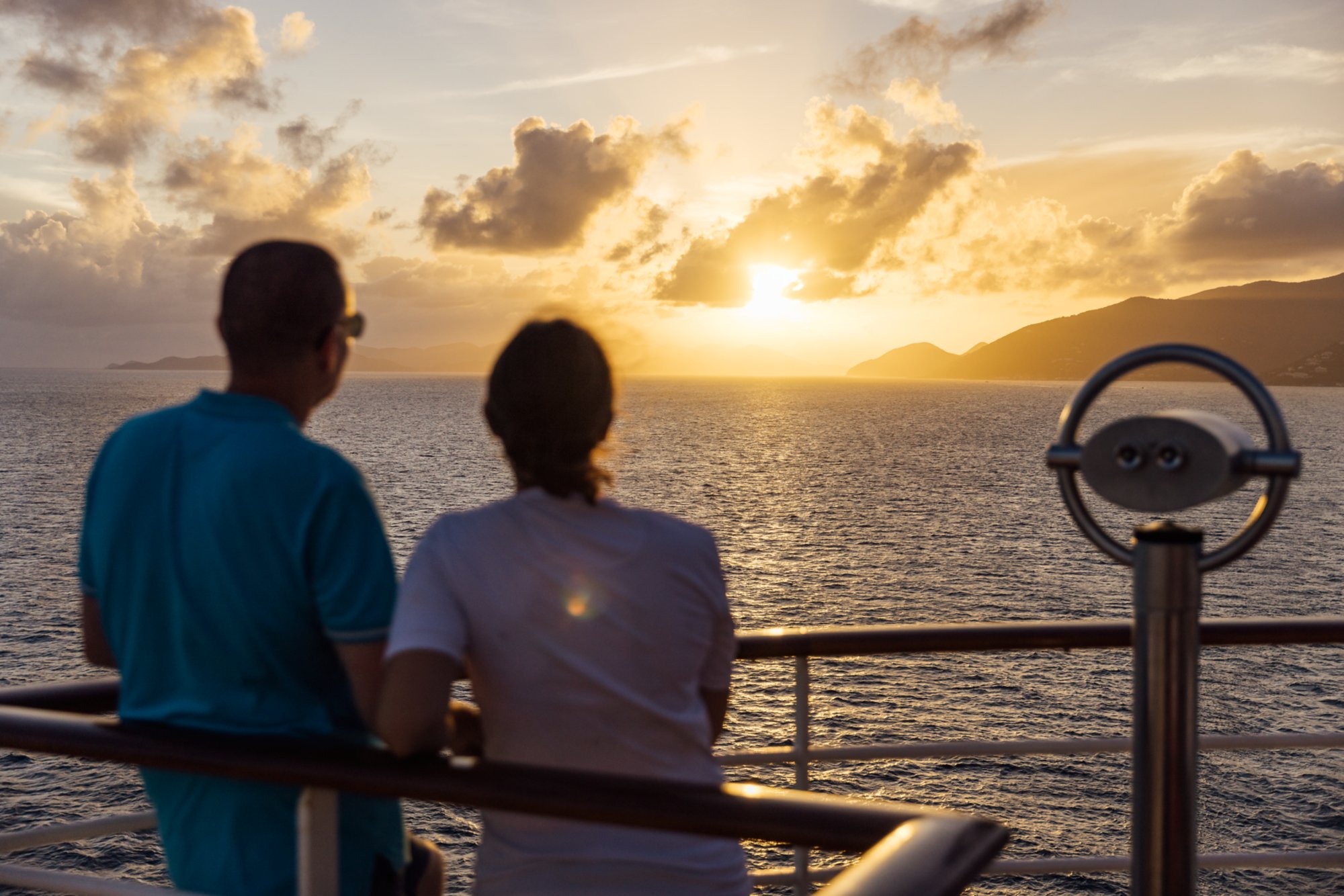 Ein Paar beobachtet den Sonnenuntergang an Deck