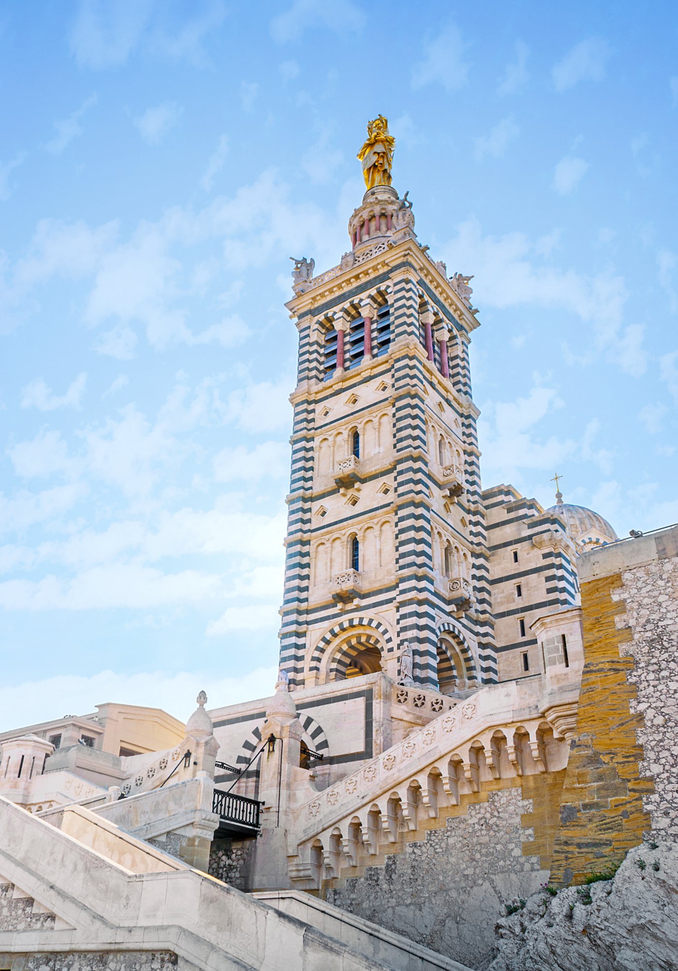 Die Basilika Notre-Dame de la Garde in Marseille thront mit goldener Marienstatue über der Stadt.
