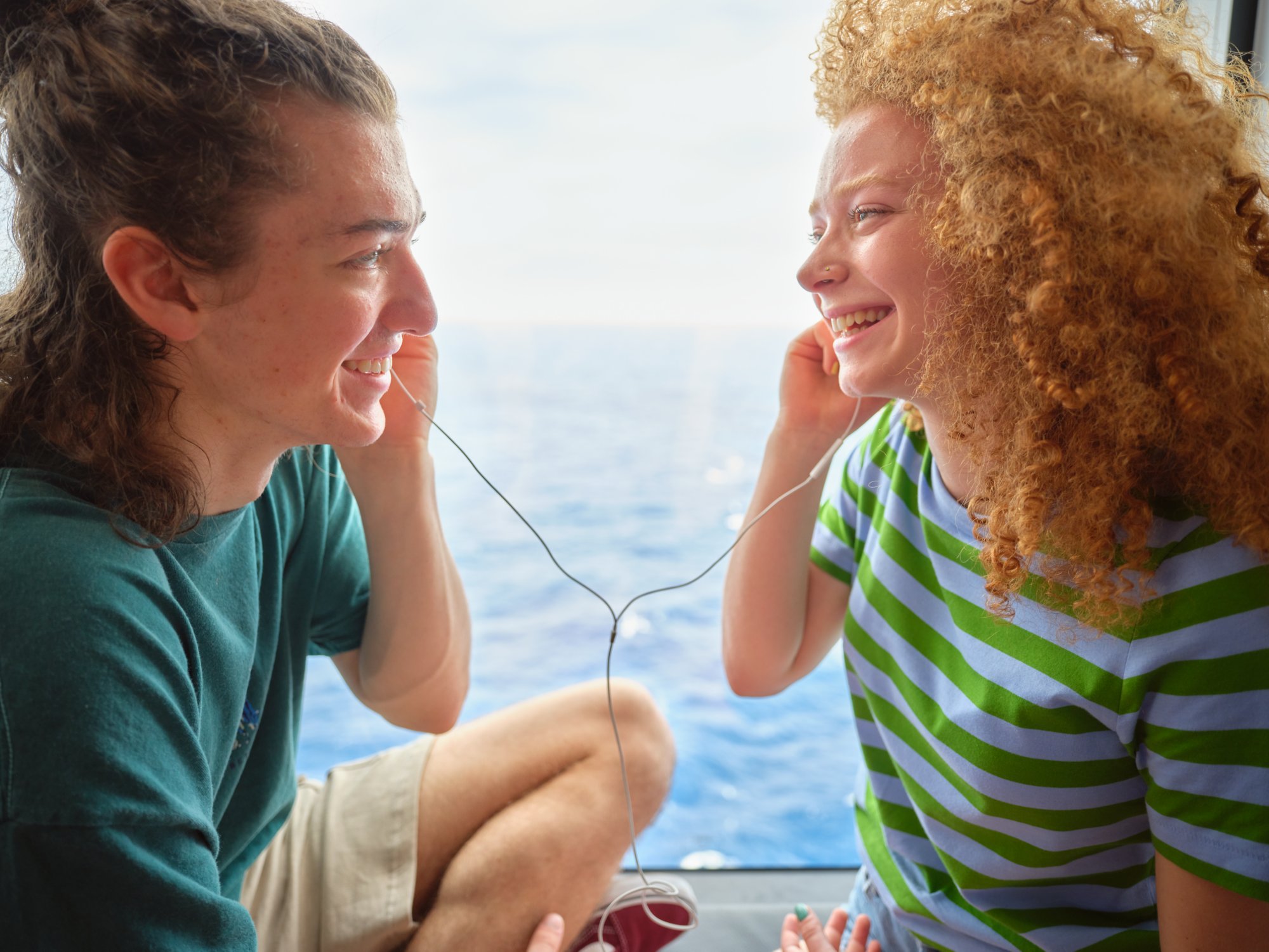 Zwei Mädchen hören mit Kopfhörern Musik