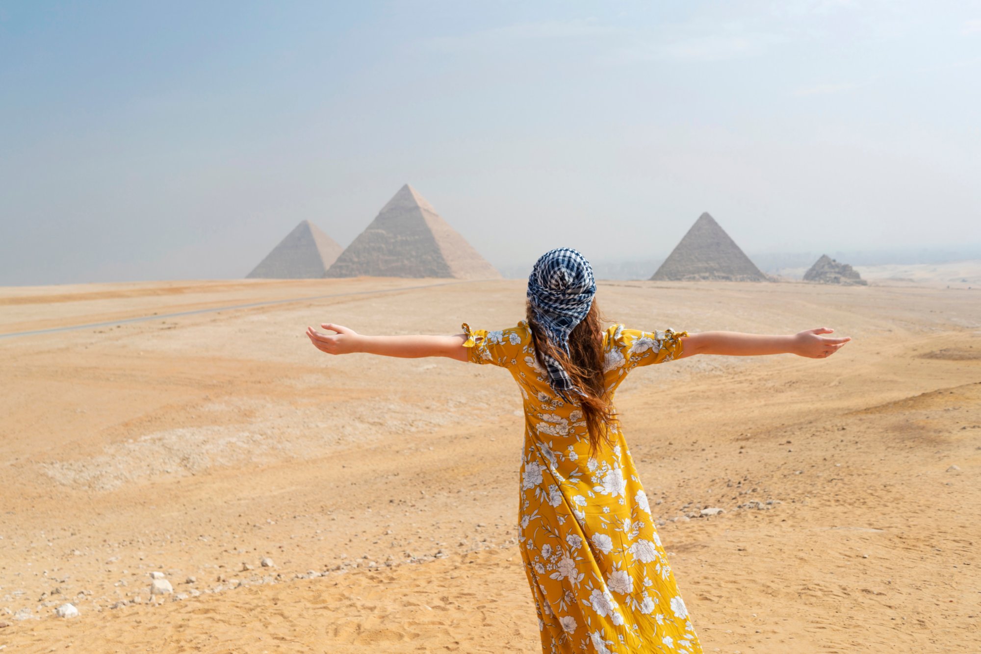 Rear view of a female tourist enjoying a tour to the Pyramids of Giza in Egypt.