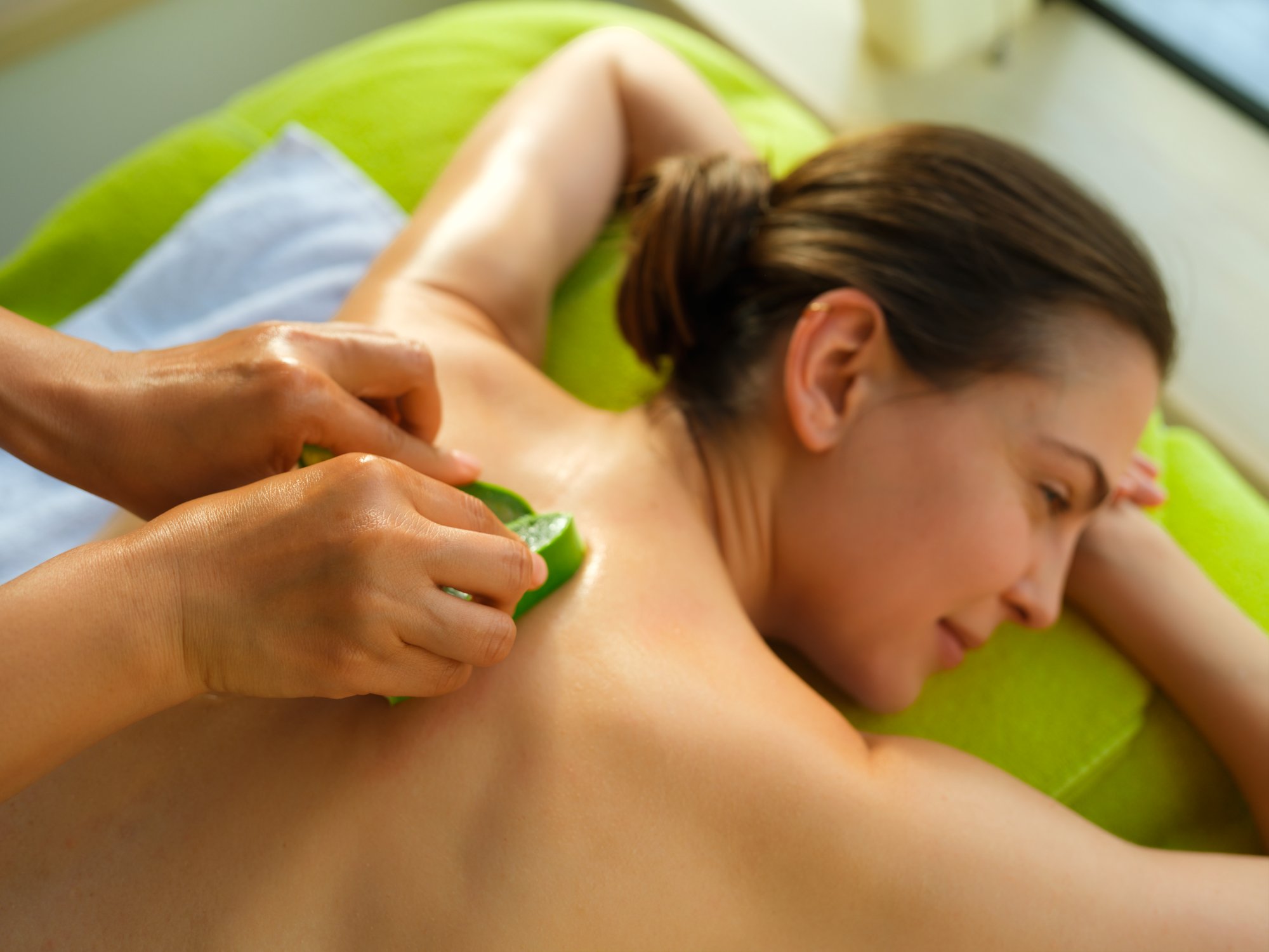 Frau wird mit Aloe Vera massiert