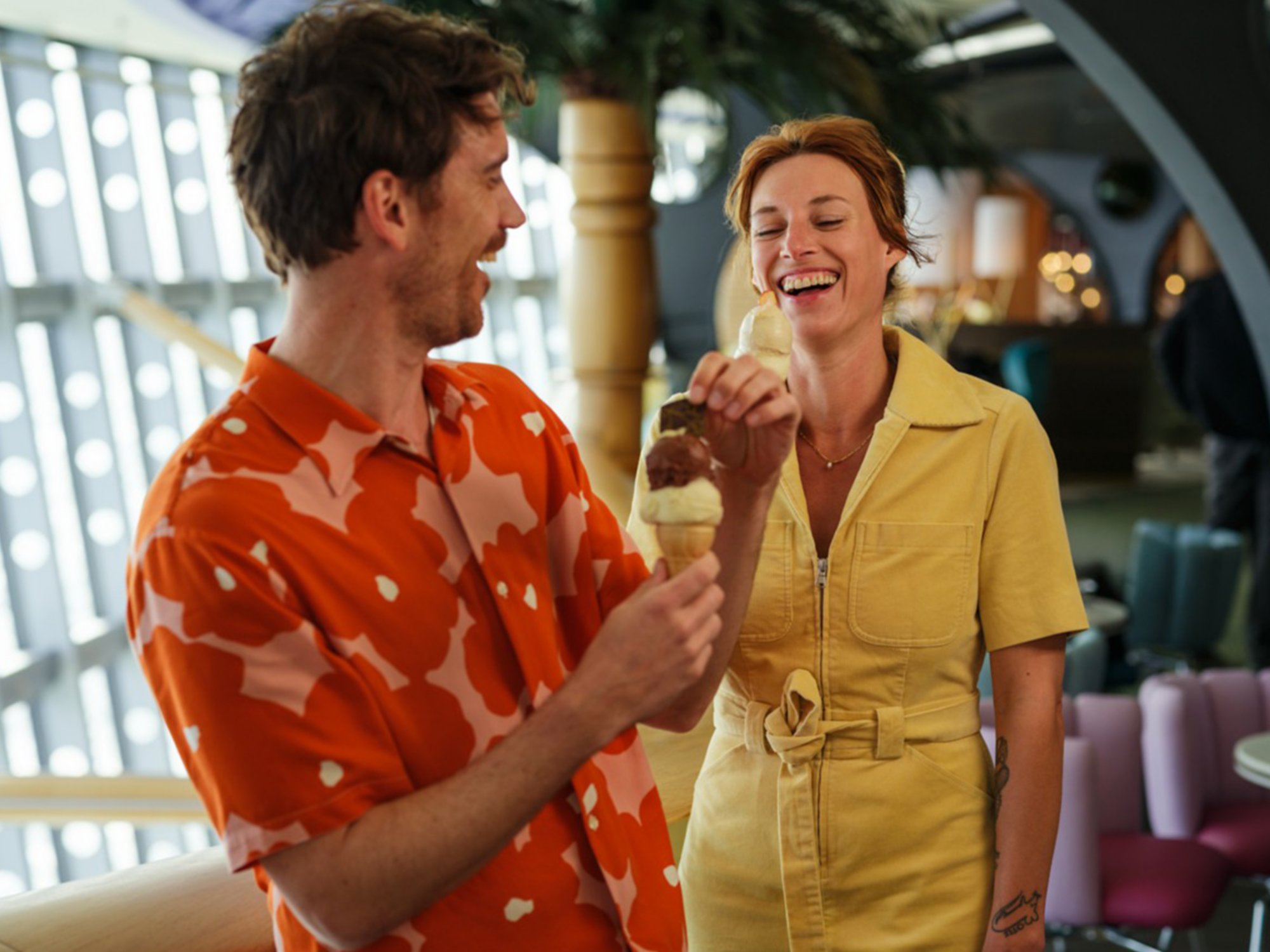 Ein Paar genießt ein Waffeleis gemeinsam im Theatrium und lachen 