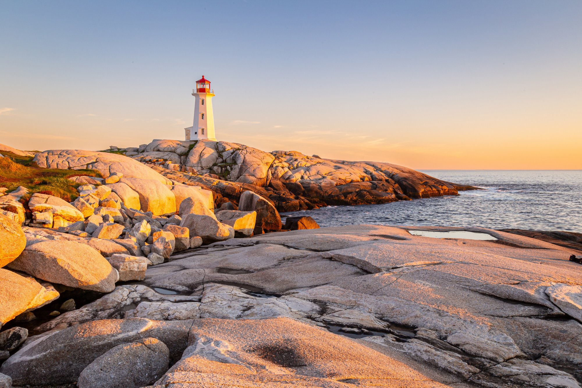 Leuchtturm von Peggy's Cove in Nova Scotia auf blankem Granit im Abendlicht 