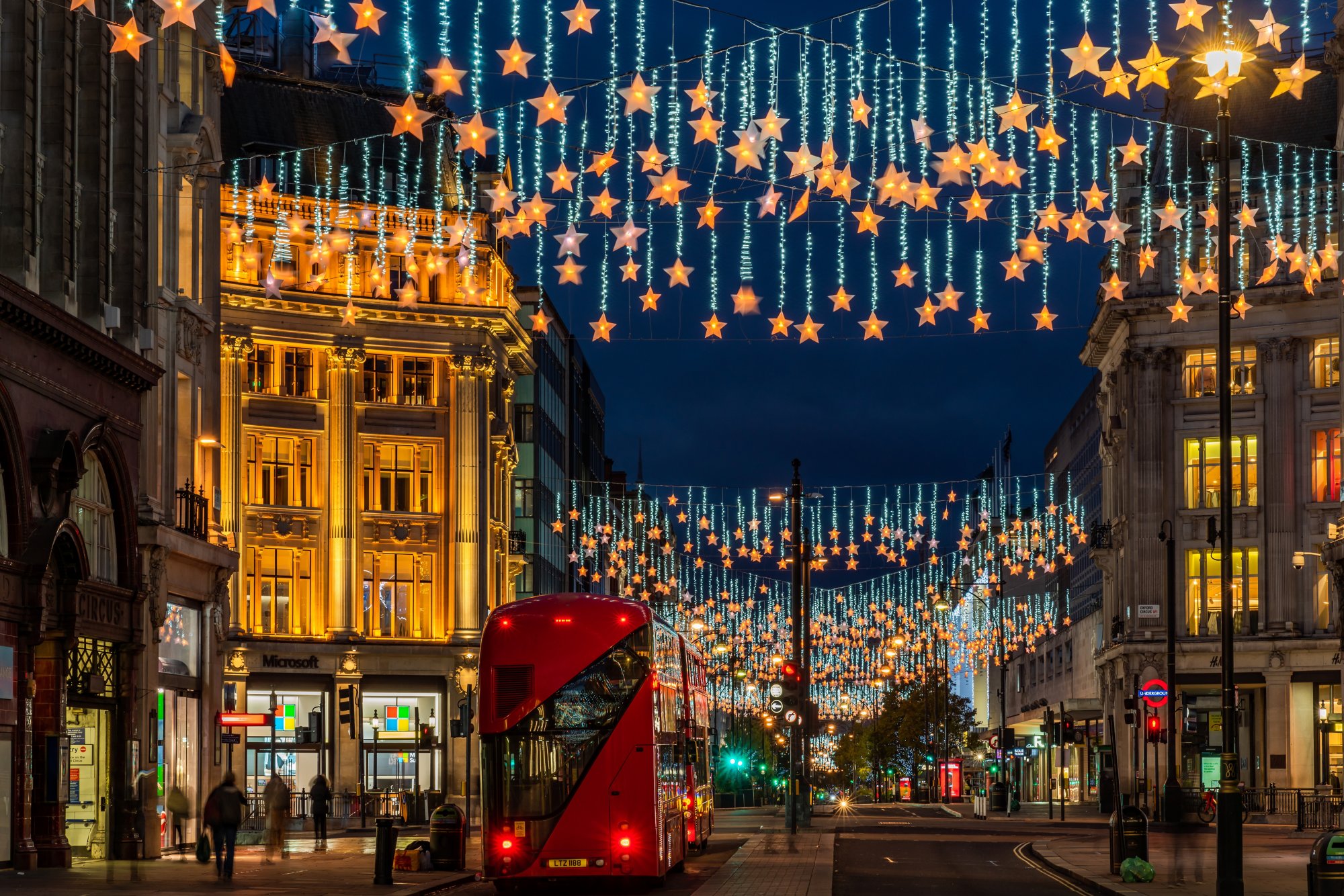 Londoner Straße mit Weihnachtsbeleuchtung und rotem Bus.