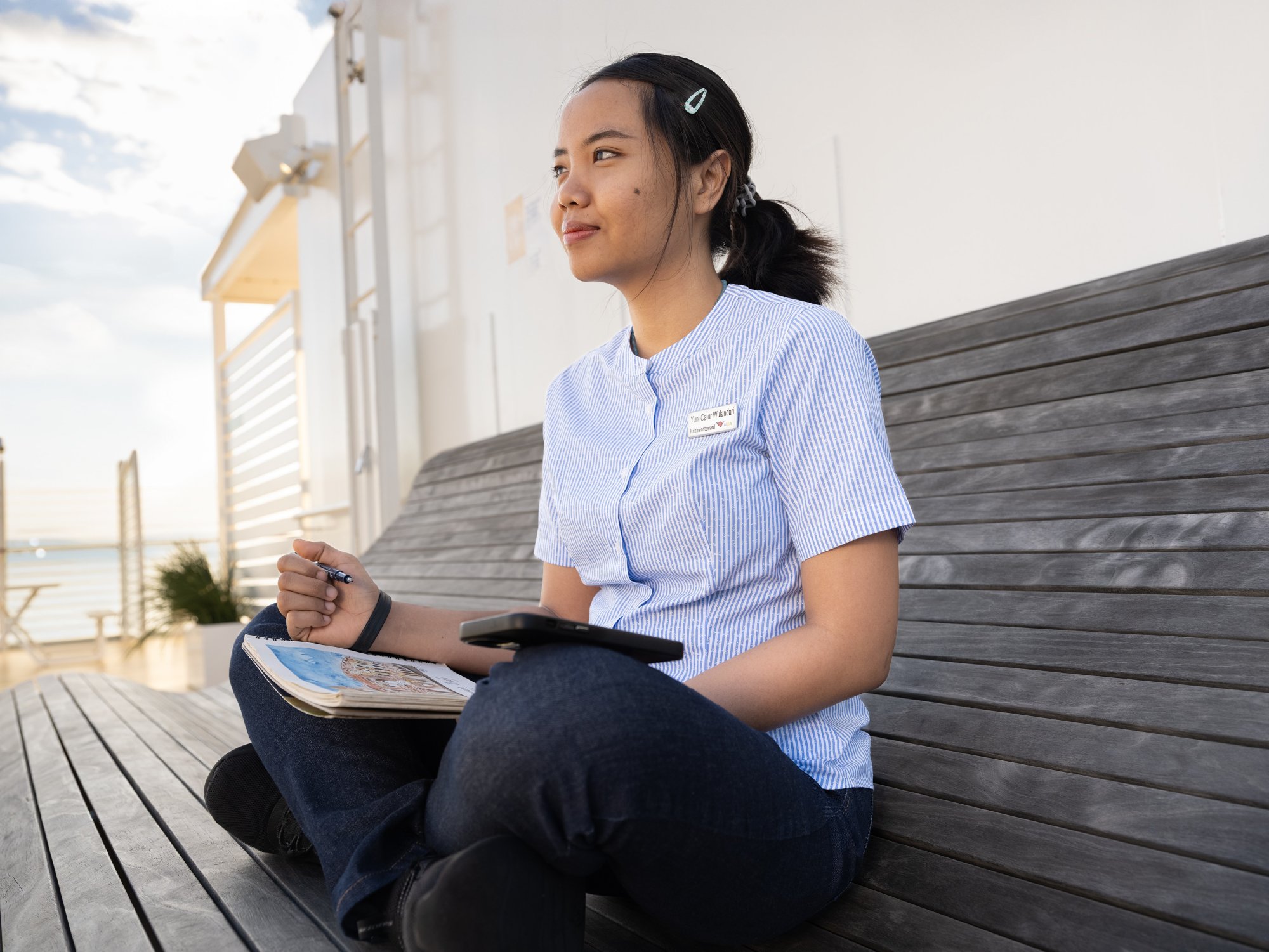 Crew member on the outside deck with mobile phone and painting pad
